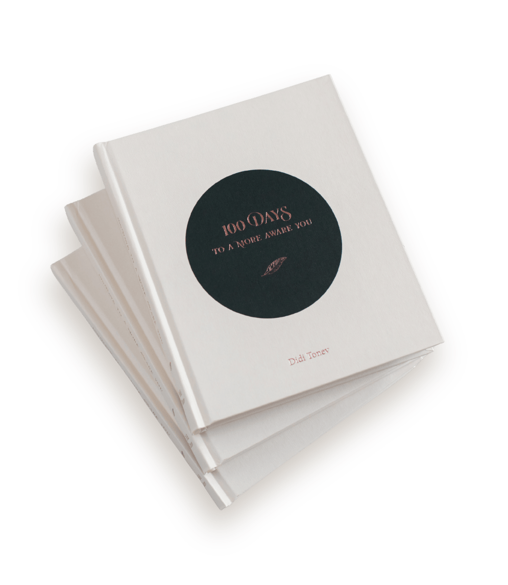 Stack of three copies of 100 Days to a More Aware You by Didi Aurelia — a lifestyle and coffee table journaling book with a cream cover and dark green embossed circle detail