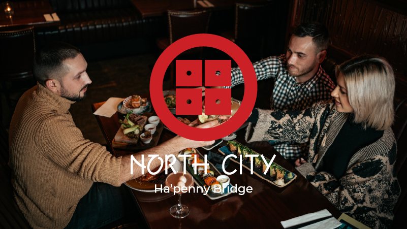 Three people dining at a restaurant table with various dishes, overlay text "North City Ha'penny Bridge" and a circular logo.
