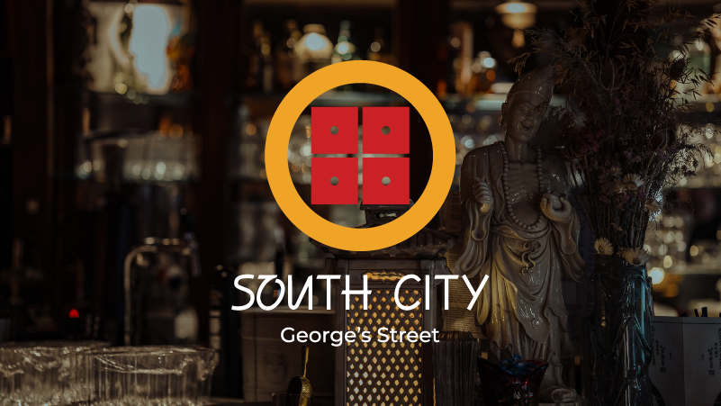 Interior of a bar with a South City George's Street logo overlay, featuring a statue of a figure, bottles, and glasses.