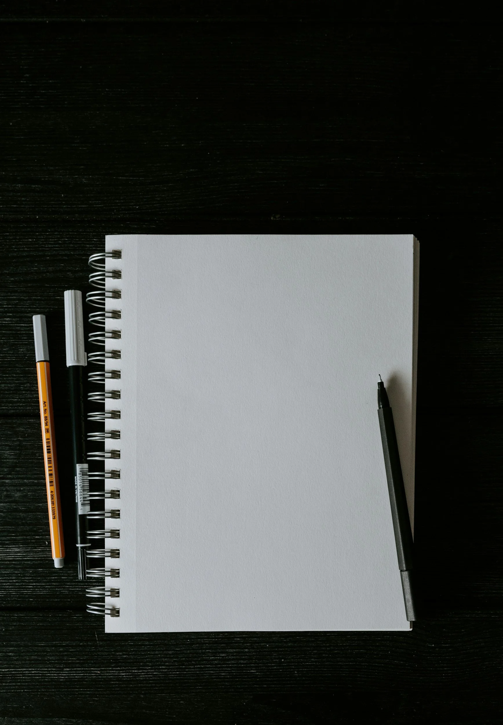 Blank notebook page with  pens and pencils.