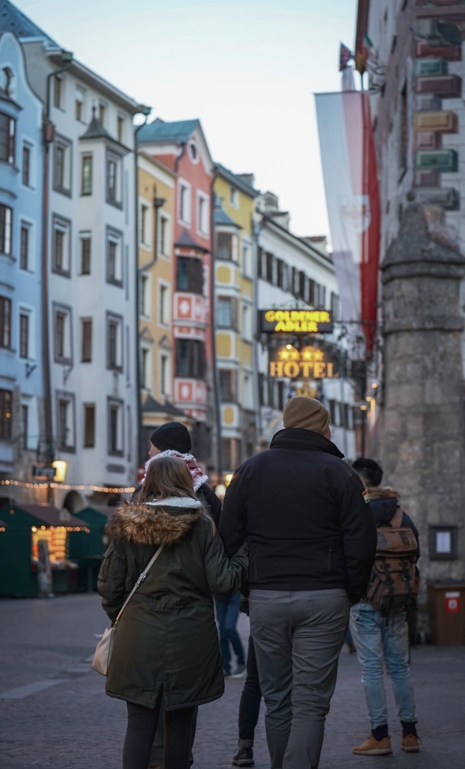 A couple walk along the Christmas market in Innsbruck, Austria, on Dec. 23, 2021. © Merit Davey 2021.
