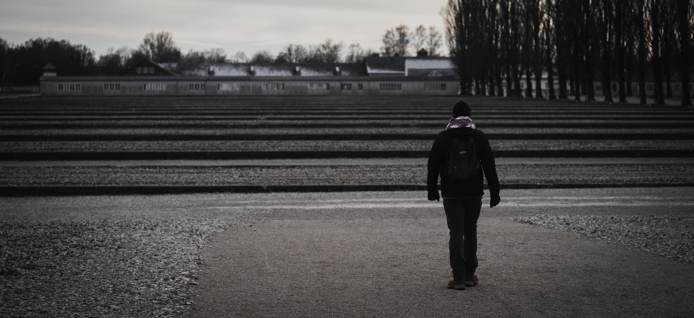 A man walks in Dachau Concentration Camp near Dachau, Germany, on Jan. 8, 2022. Only a handful of the camp barracks remain standing, but the surviving foundations speak to the camp's former footprint. Although the trip culminated inside a grim piece