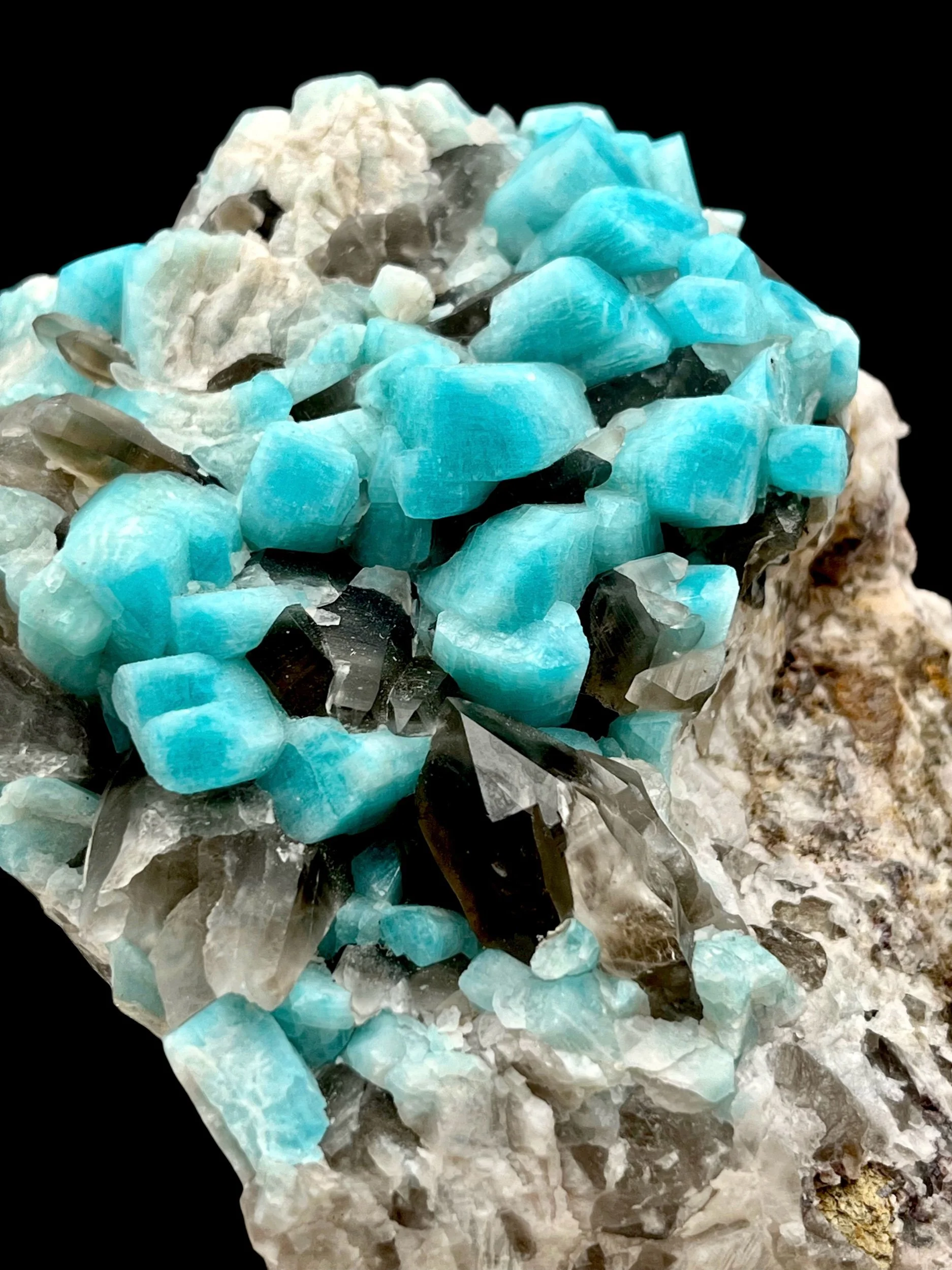 Blue amazonite crystals with smoky quartz cluster on feldspar matrix