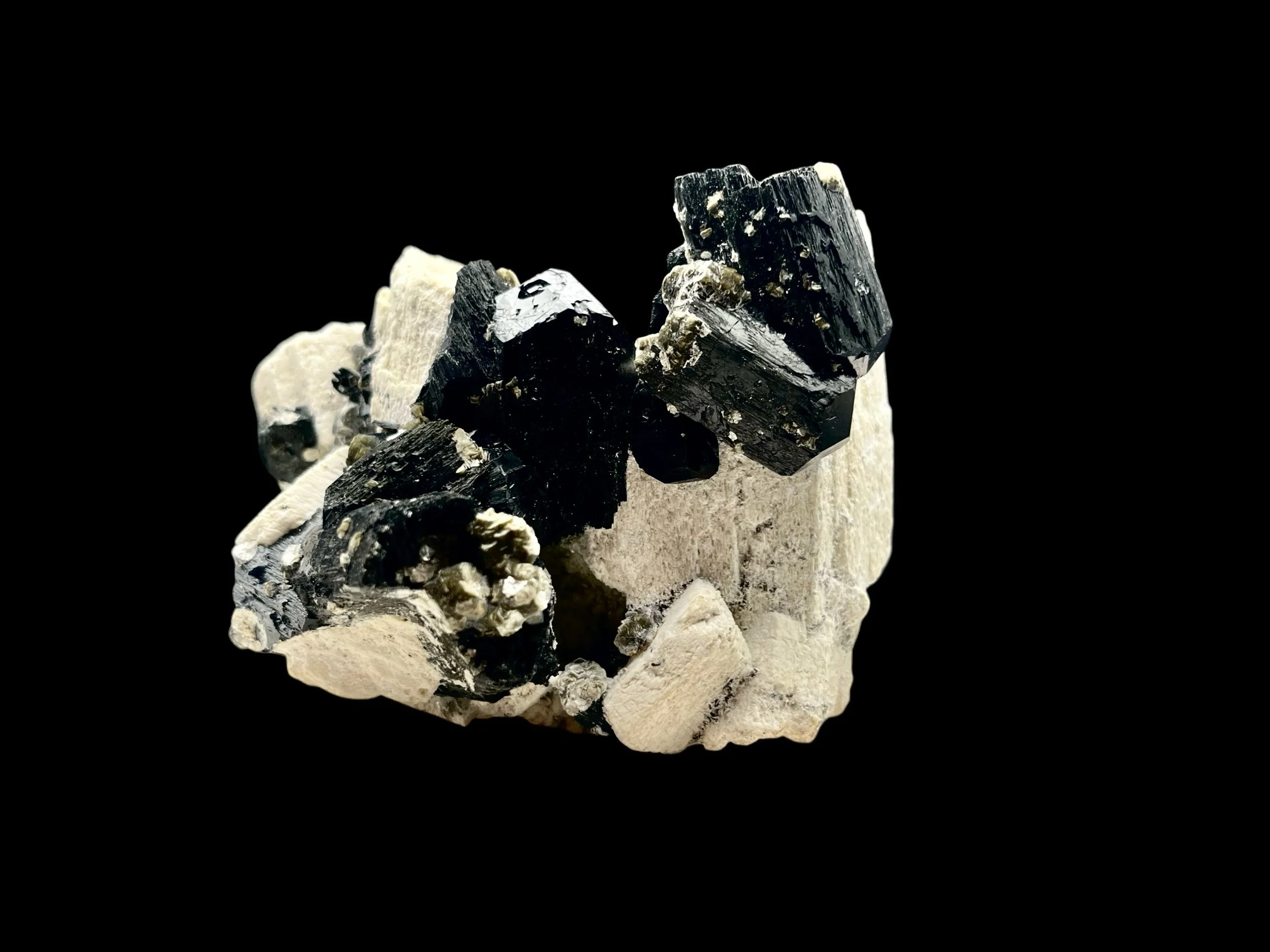 Lustrous black tourmaline crystals on pale feldspar with glowing hyalite opal
