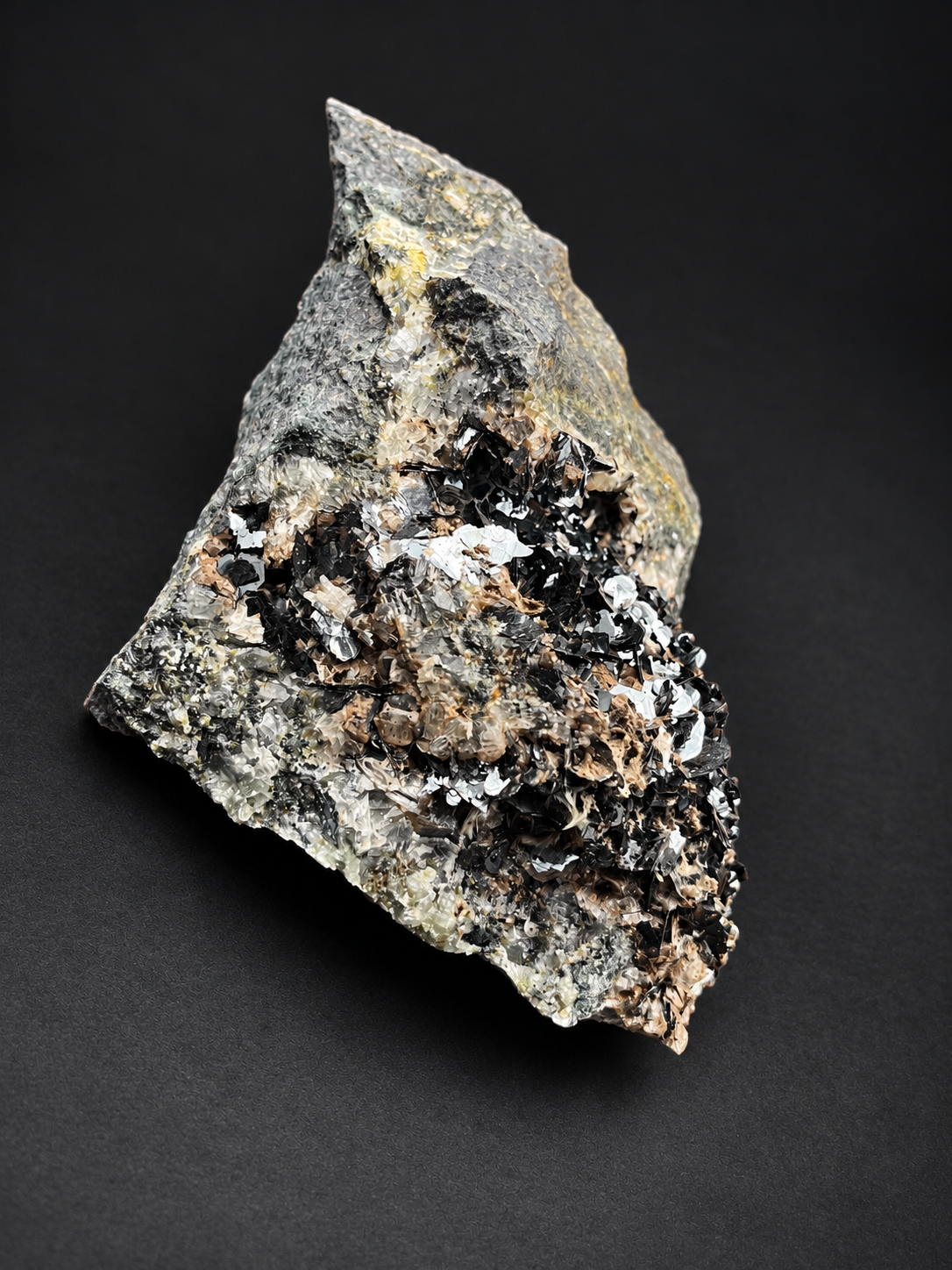 Large bladed hematite specimen from Nador, Morocco, featuring dense clusters of reflective black metallic crystals beside natural gray host rock.