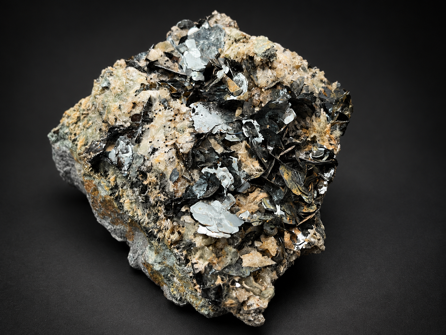 Nador Morocco bladed hematite specimen featuring large silver-black reflective crystal plates surrounded by smaller metallic blades and pale natural rock.