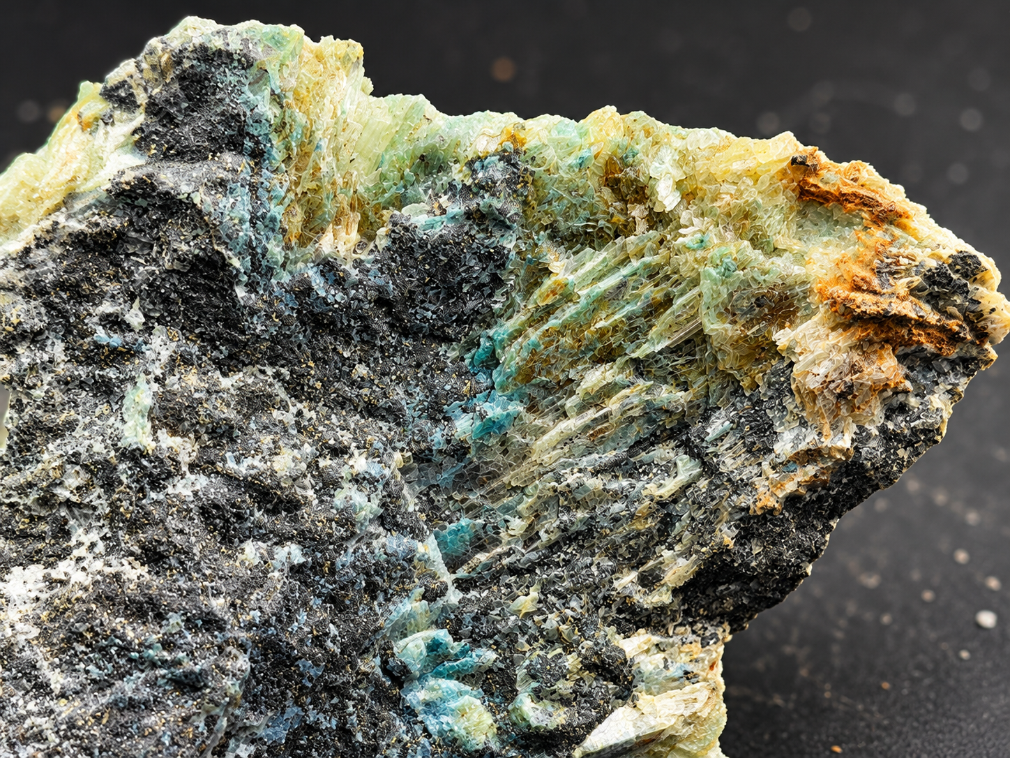 glassy selenite crystals surrounded by seafoam green mineralization, dark matrix, and rusty-orange accents.