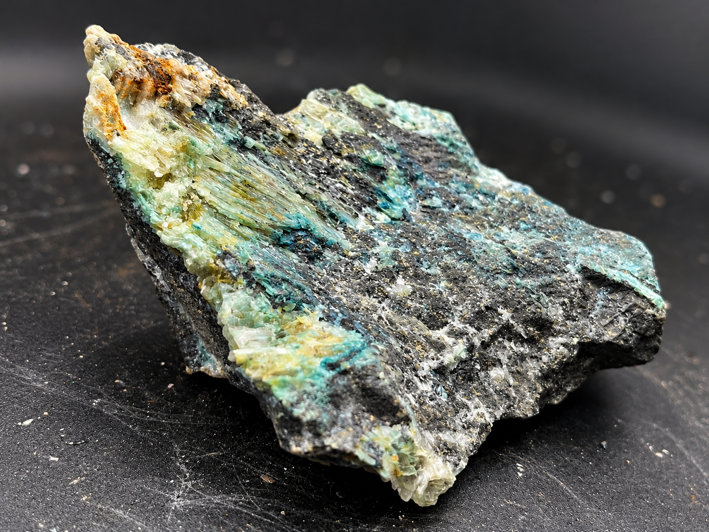 ranslucent selenite crystals with pale green and creamy yellow coloration growing across a dark mineral surface from Ojuela Mine.