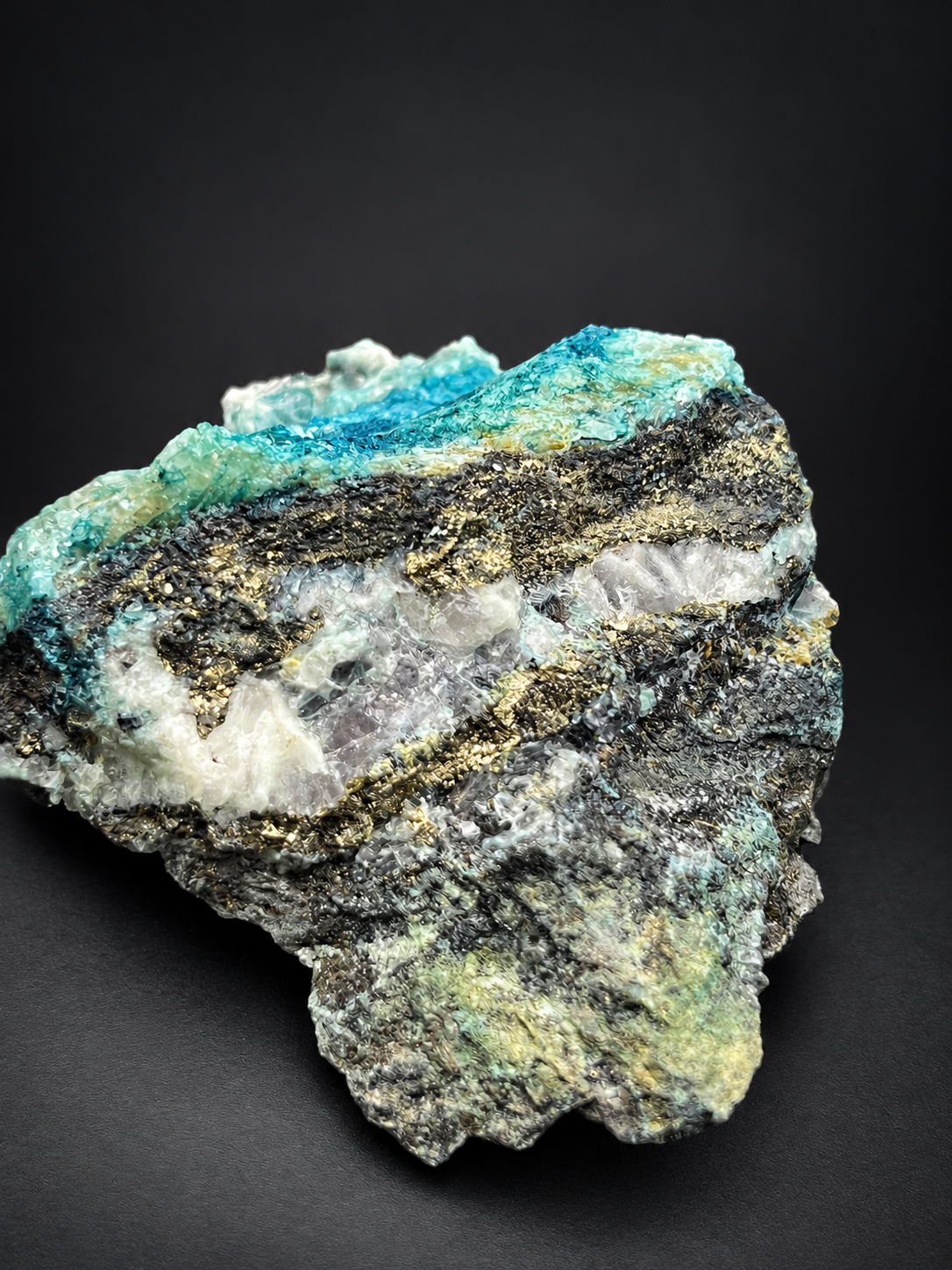 Mexican Blue Selenite showing cascading blue-green mineral textures, clear crystals, and contrasting dark matrix.