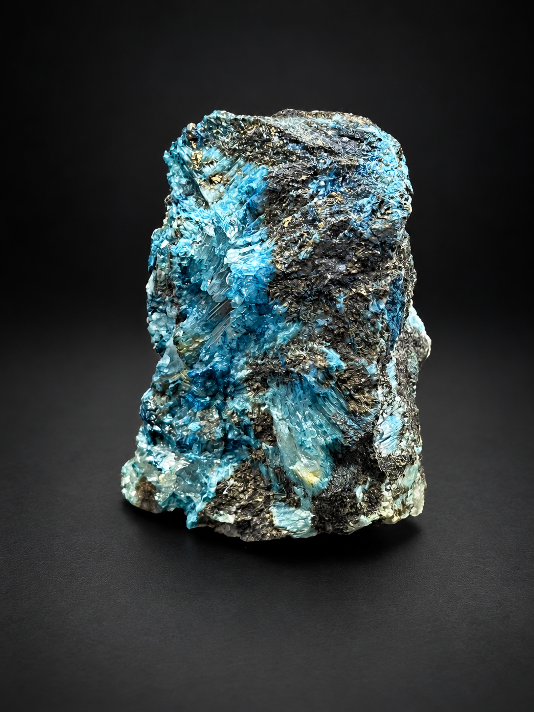 Mexican Blue Selenite specimen showing cream-colored translucent crystal formations rising above deep blue mineralization and dark textured matrix.