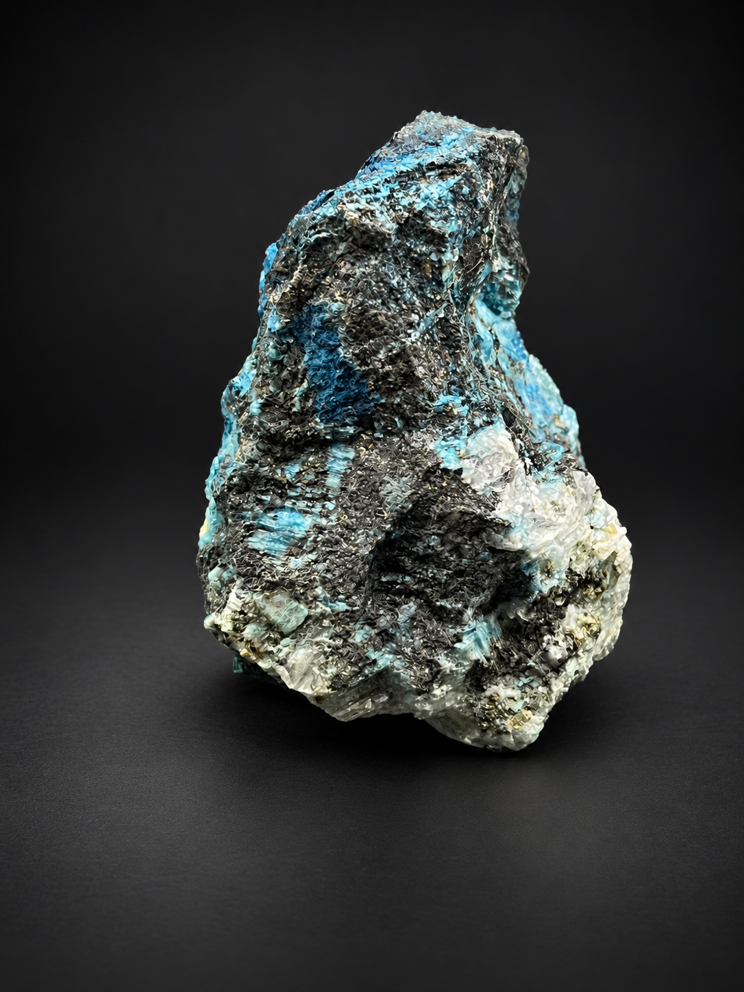 Mexican Blue Selenite specimen showing cream-colored translucent crystal formations rising above deep blue mineralization and dark textured matrix.