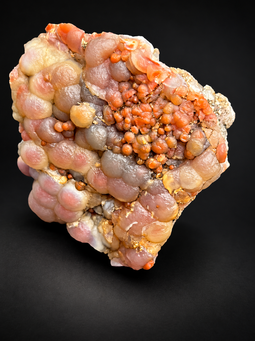 natural Red Grape Agate from Utah featuring soft pink, peach, gray, and orange rounded chalcedony formations with smaller bead-like clusters.