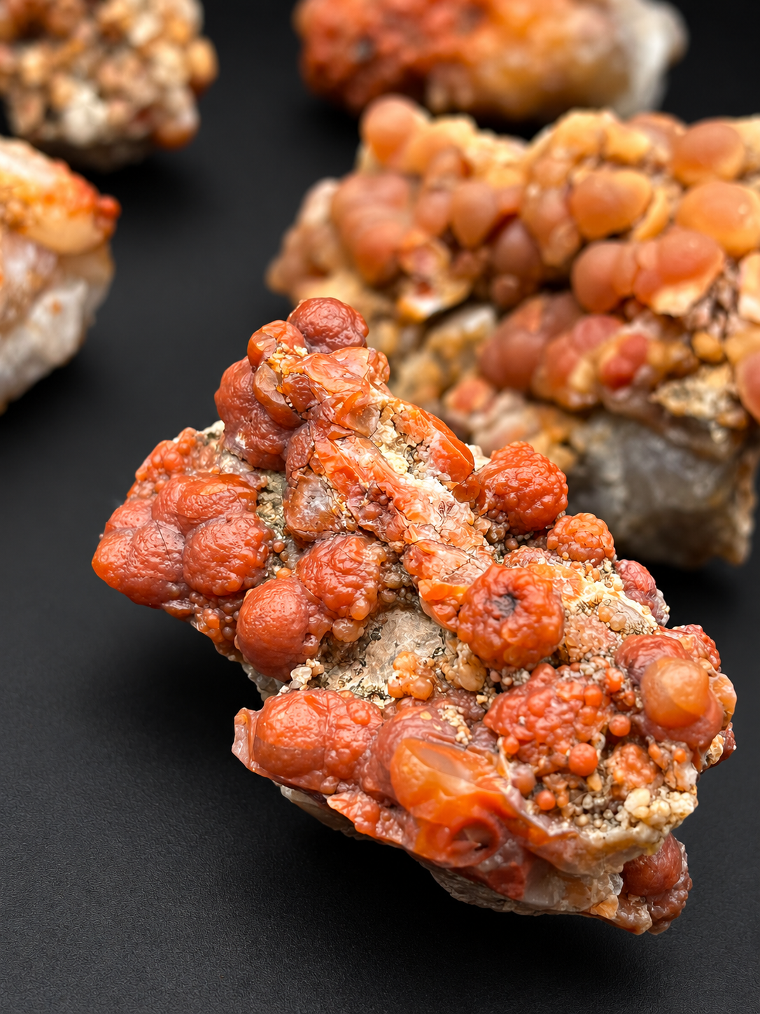 Utah Red Grape Agate featuring deep reddish-orange botryoidal formations, rounded chalcedony nodules, and textured mineral matrix.