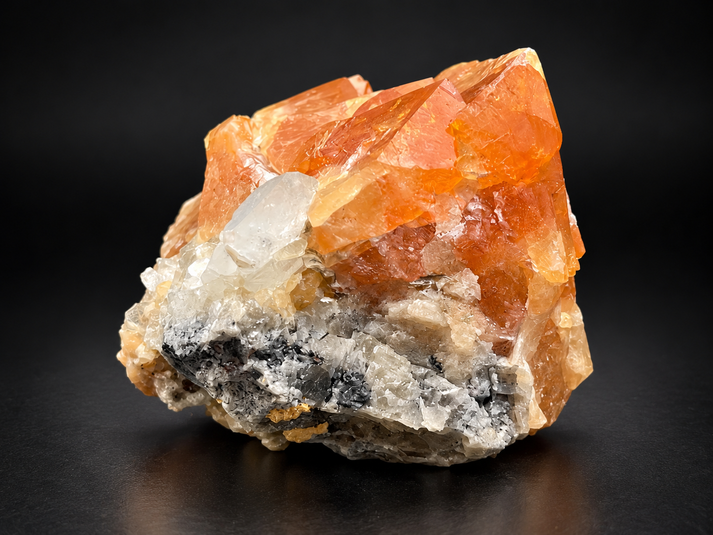 Orange scheelite from Mt. Xuebaoding, China, displaying brilliant icy-blue and white fluorescence under ultraviolet light, beside clear calcite