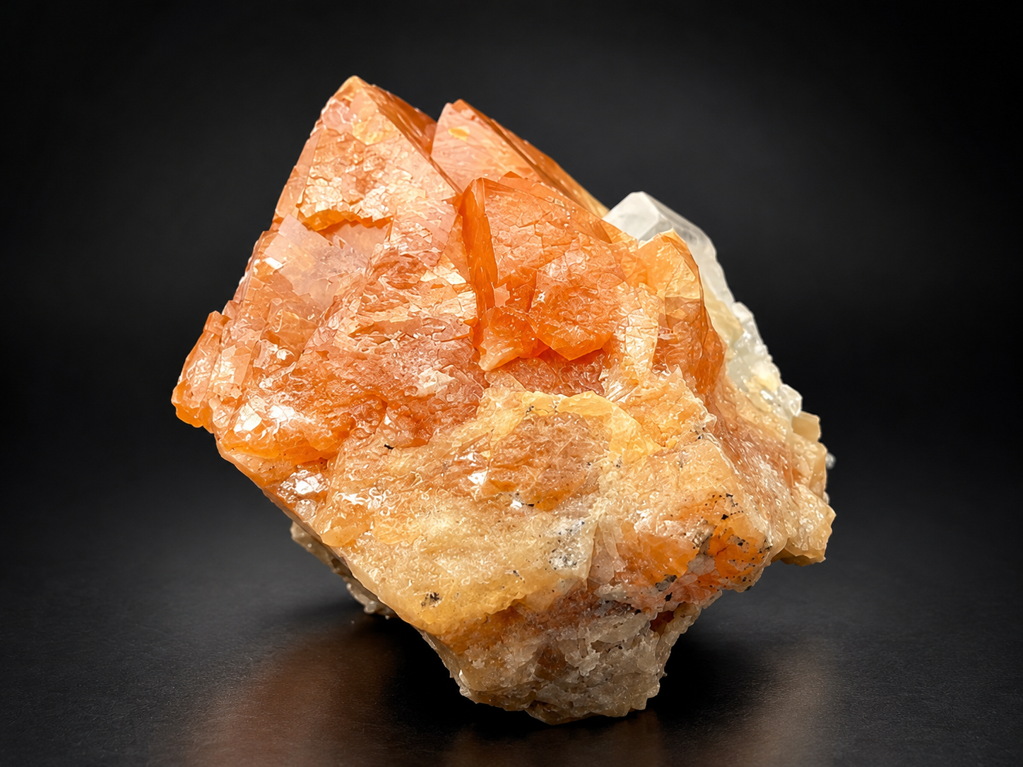 vivid tangerine-orange scheelite crystals displaying lustrous faces, pointed crystal formations, and cream-colored muscovite from Sichuan, China.