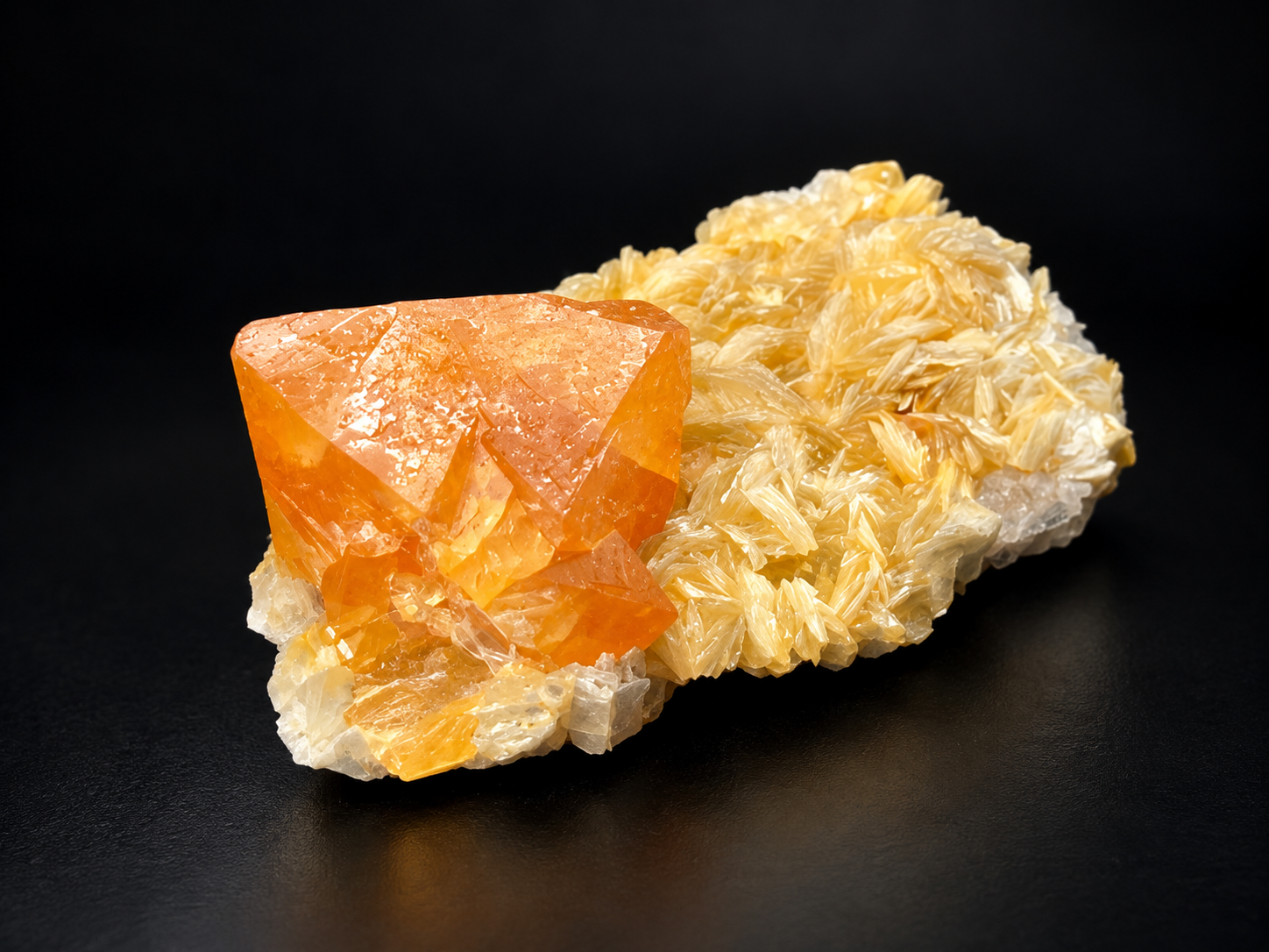 Bright orange scheelite crystal on champagne-gold muscovite rosettes from Mt. Xuebaoding, China, showing contrasting geometric and flower-like formations.