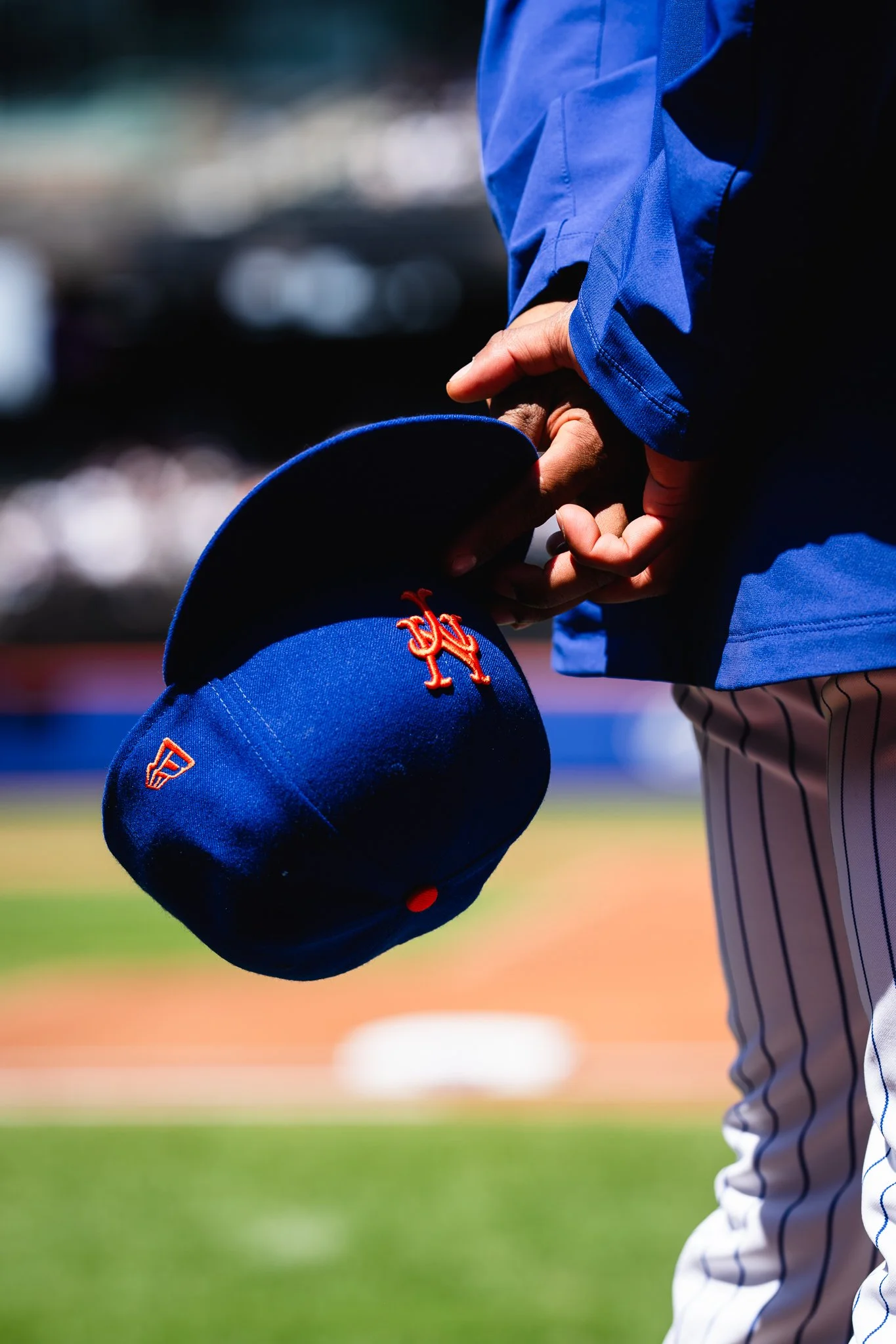New York Mets player holds cap.