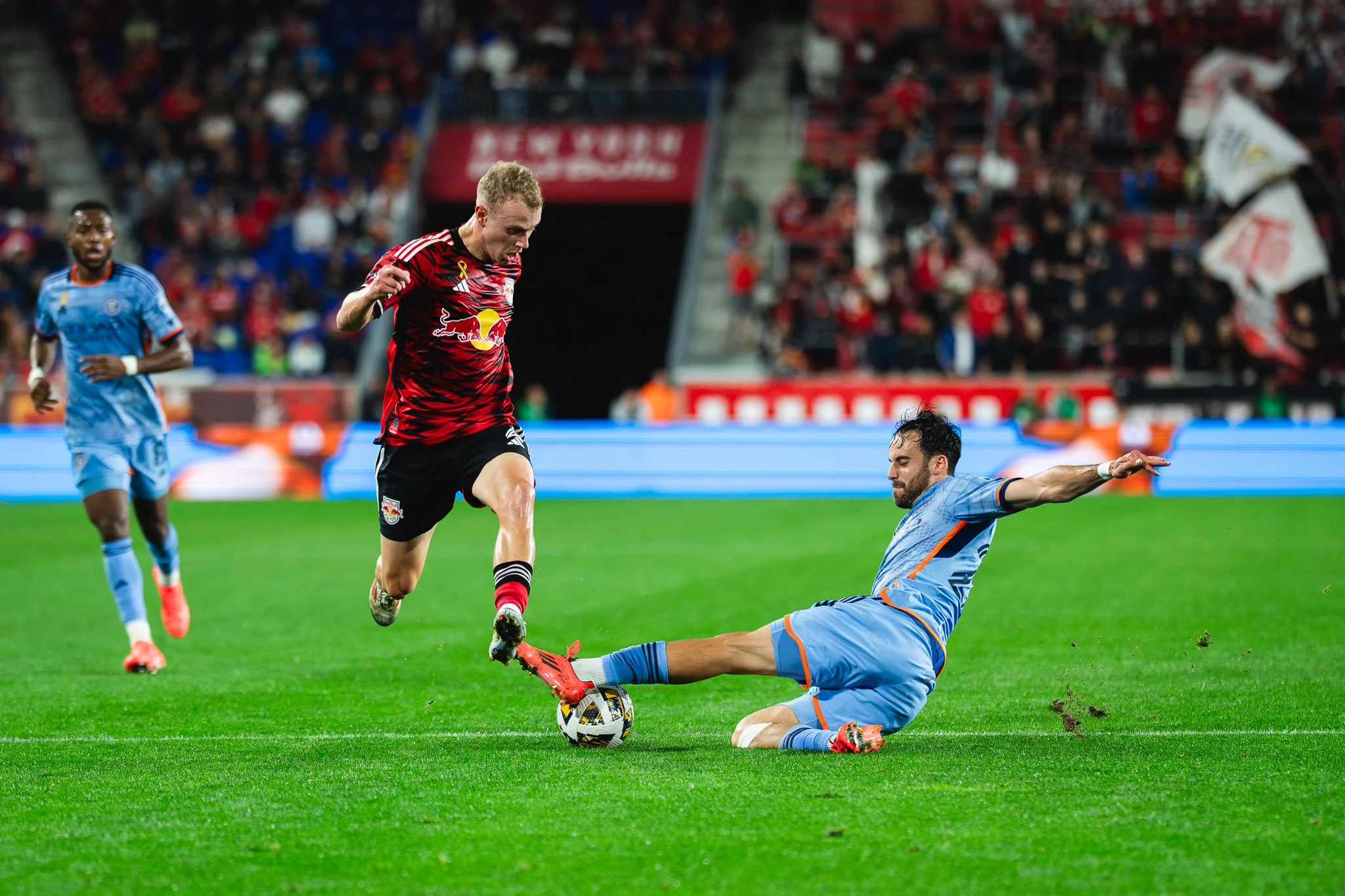 Dennis Gjengaar of New York Red Bulls is tackled by Kevin O'Toole of NYCFC.