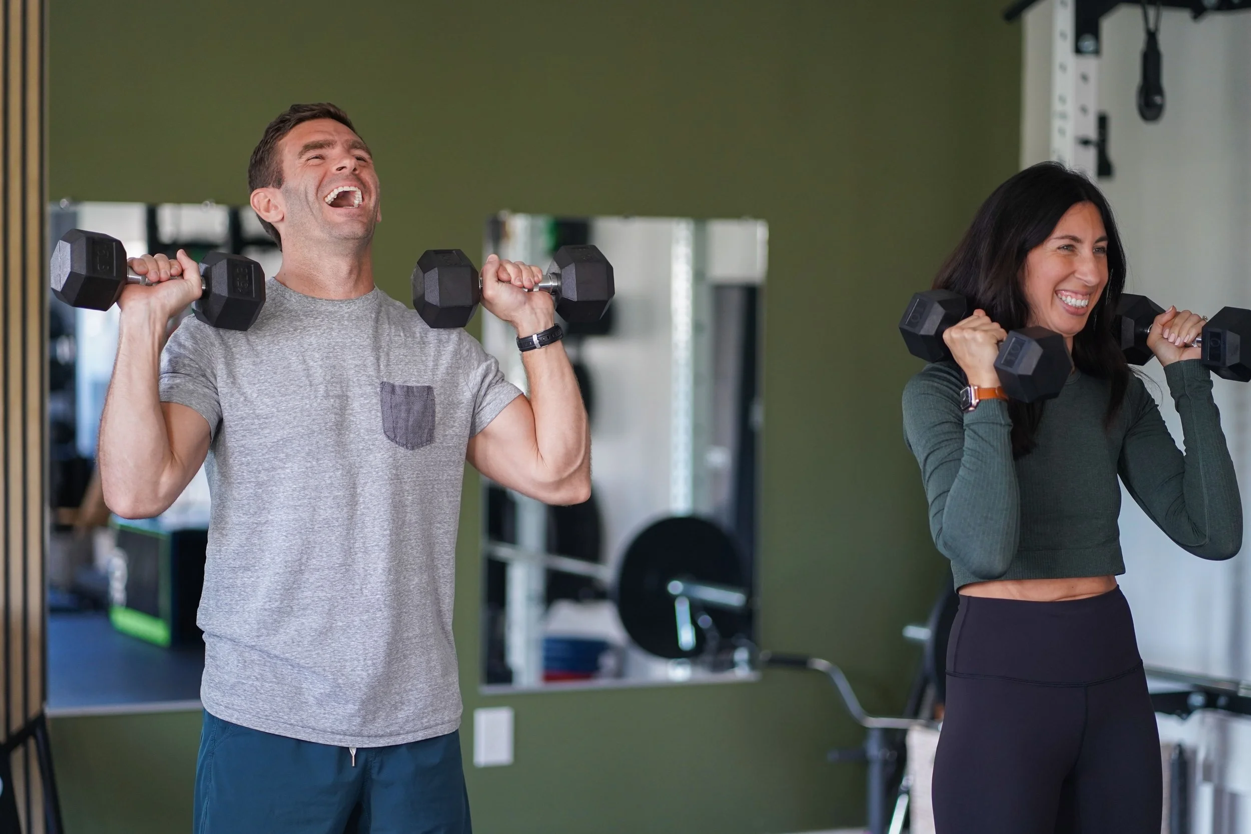 two happy smiling people exercising together in 2:1 personal training