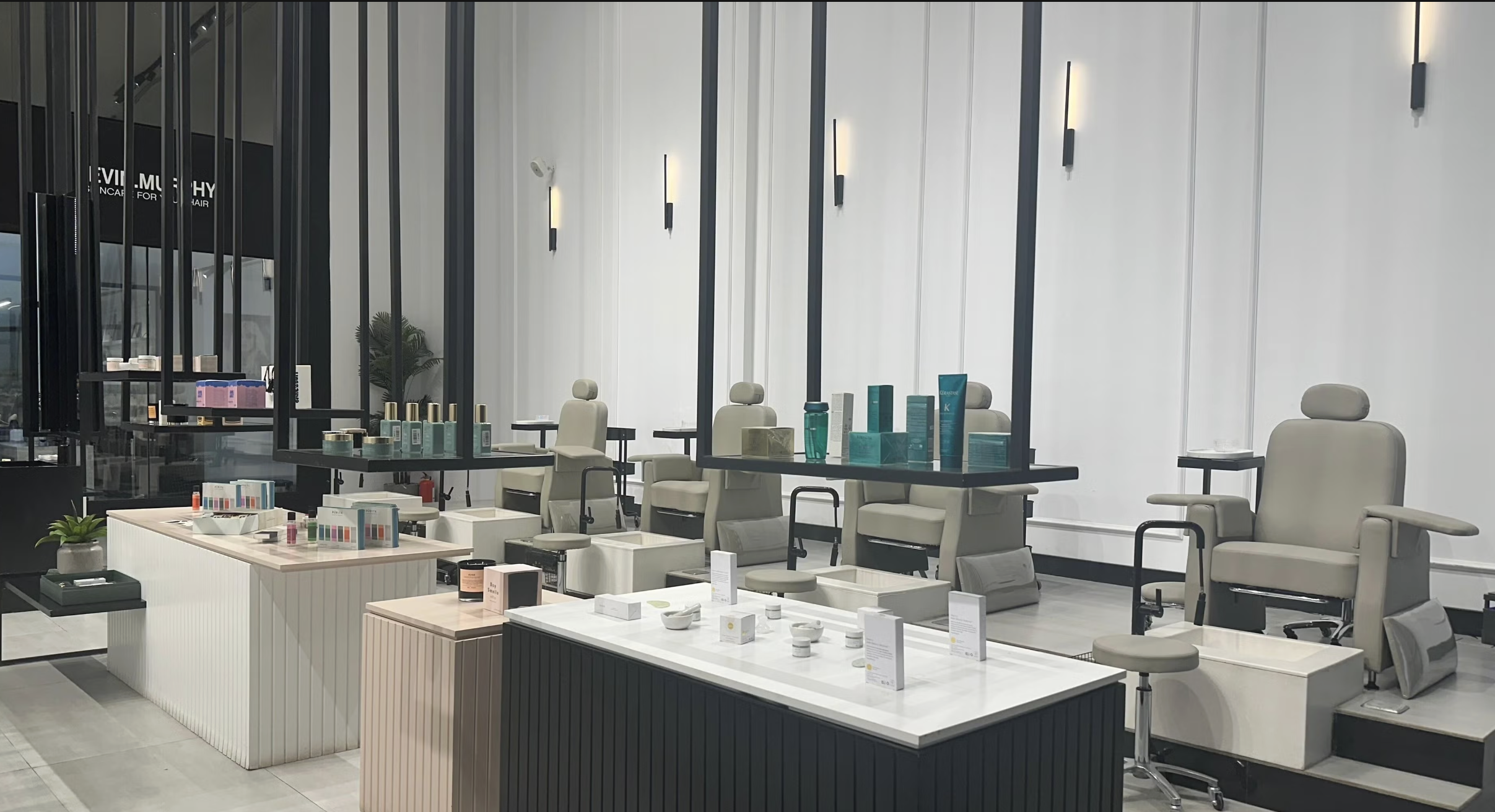 Beauty salon or spa with reclining chairs, product displays, and modern lighting.