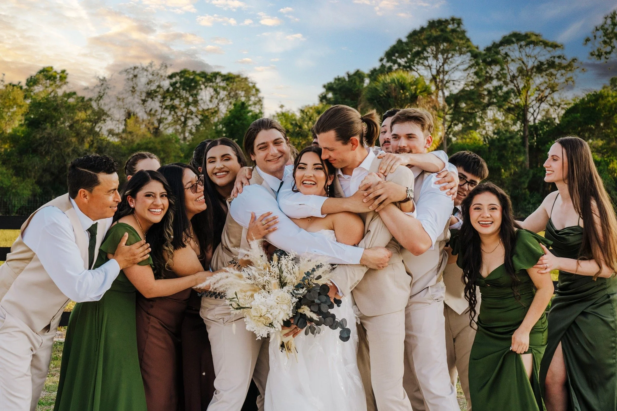 Wedding party showing love to the bride and groom in a surprise hug attack. 