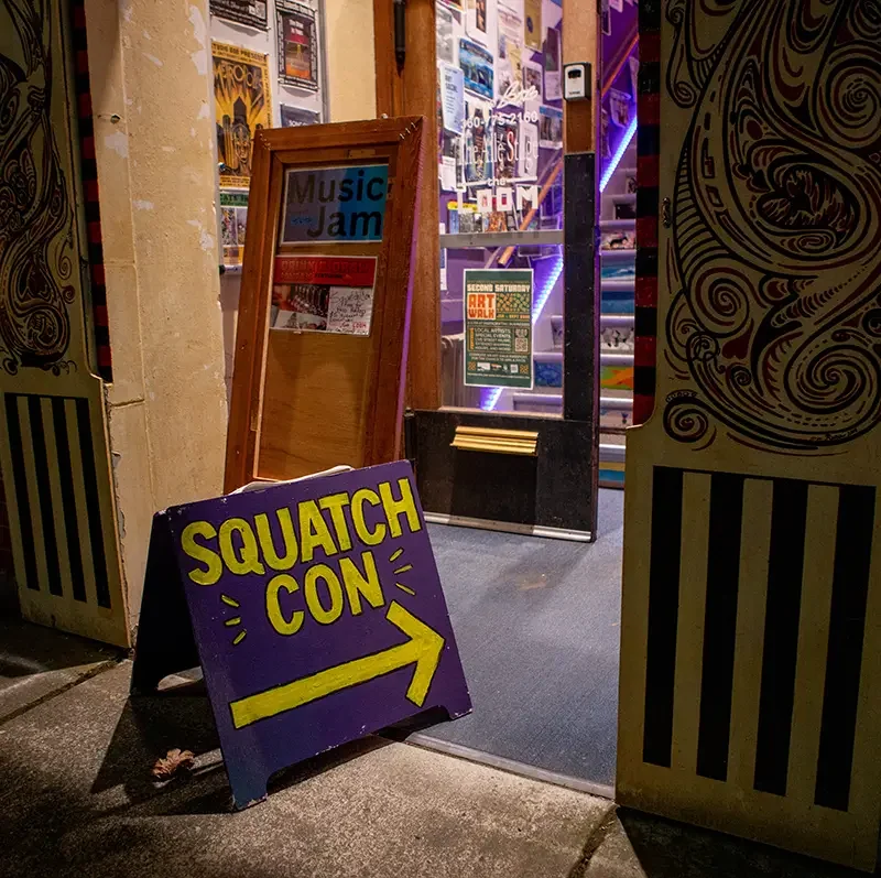 Business with squatchcon sign pointing in