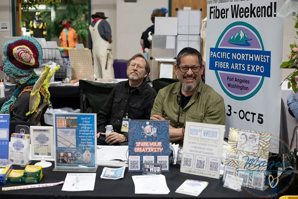 two men smile at booth