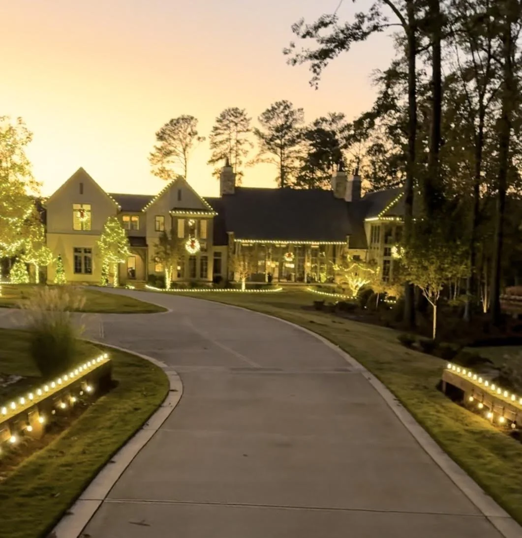 Warm cast brass low-voltage LED landscape uplighting illuminating an Athens GA neighborhood HOA entrance monument sign