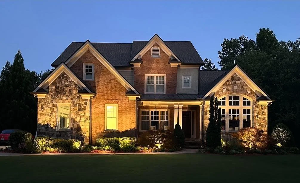 Custom low voltage architectural facade uplighting and brass pathway fixtures installed on a home in Athens GA