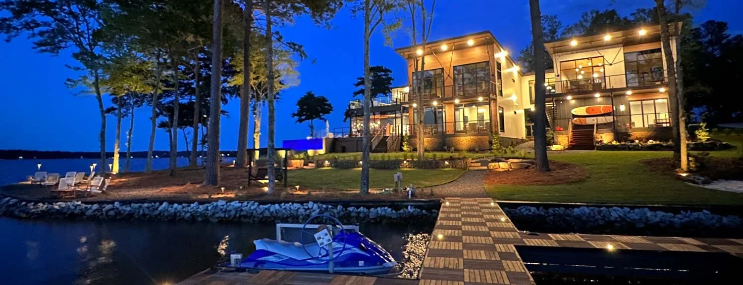 Luxury waterfront estate with architectural facade uplighting and stone patio illumination at Reynolds Lake Oconee