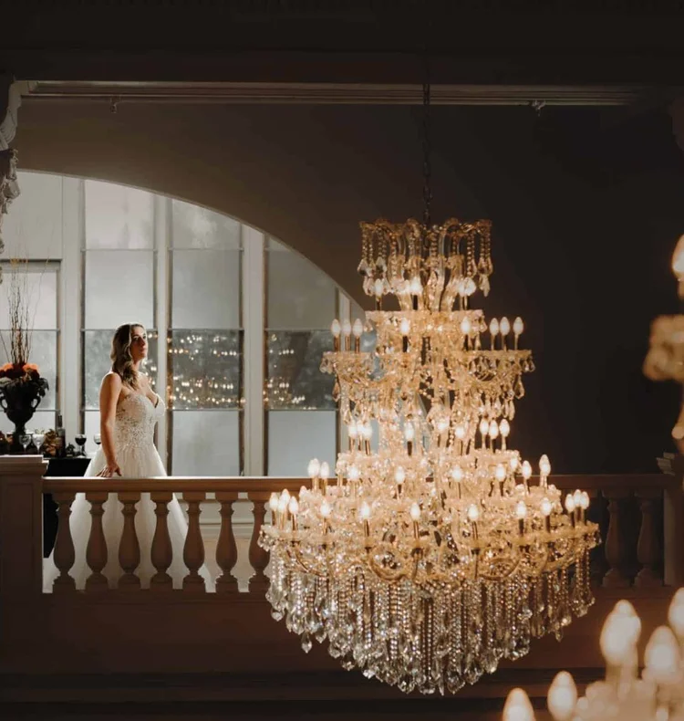 A bride on the Katy Depot mezzanine beside a tiered crystal chandelier