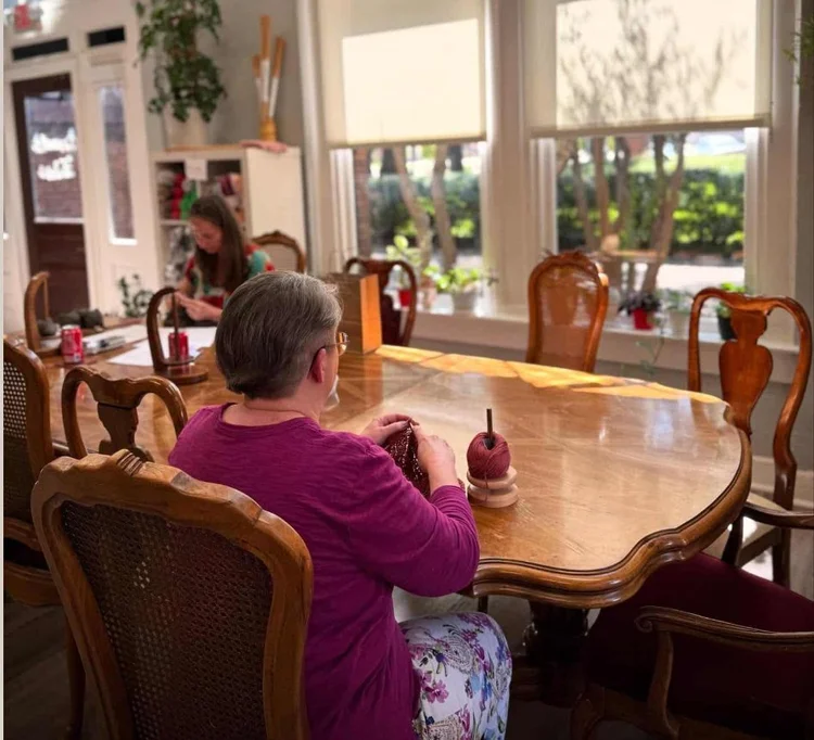 Knitters at a sunny table during Social Stitching at Quixotic Fibers in the Katy Depot