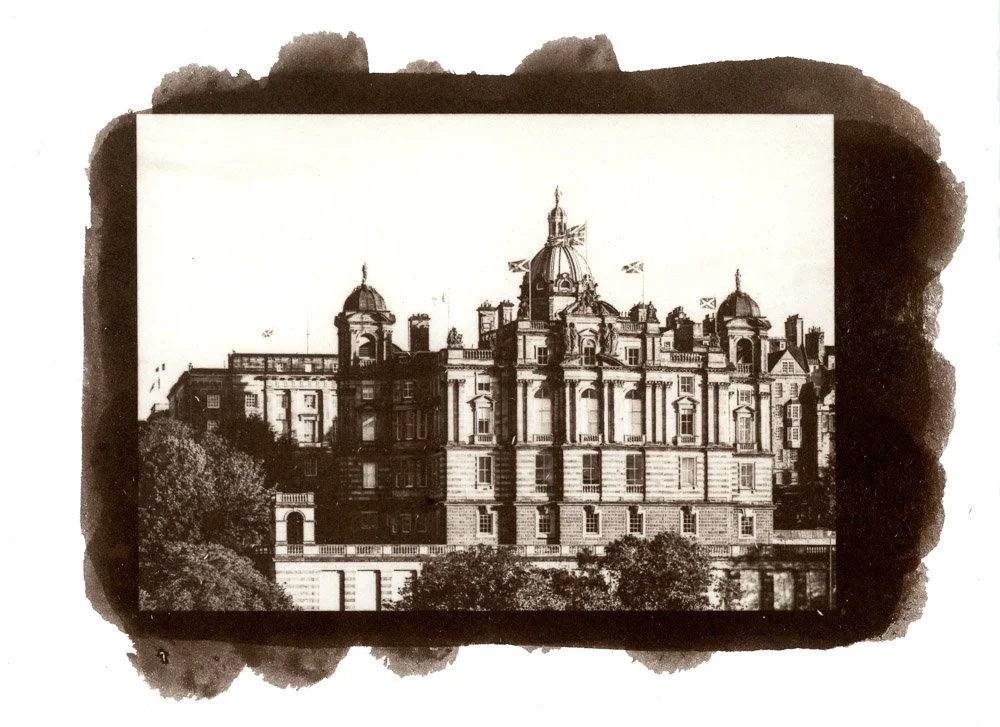 A Salt Print of a photograph of a large, ornate hotel building with multiple towers and flags, in Edinburg, Scotland.