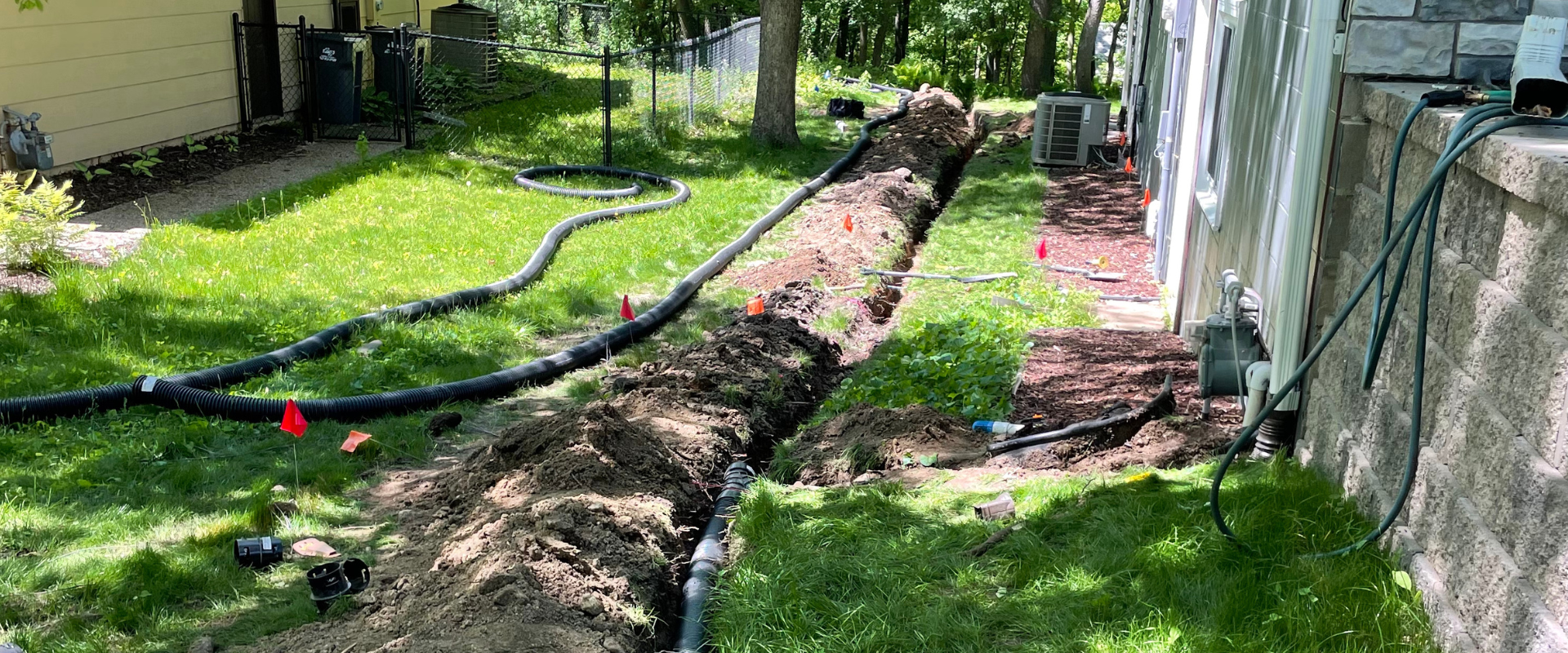 Yard trench with black conduit pipe installation for underground utilities