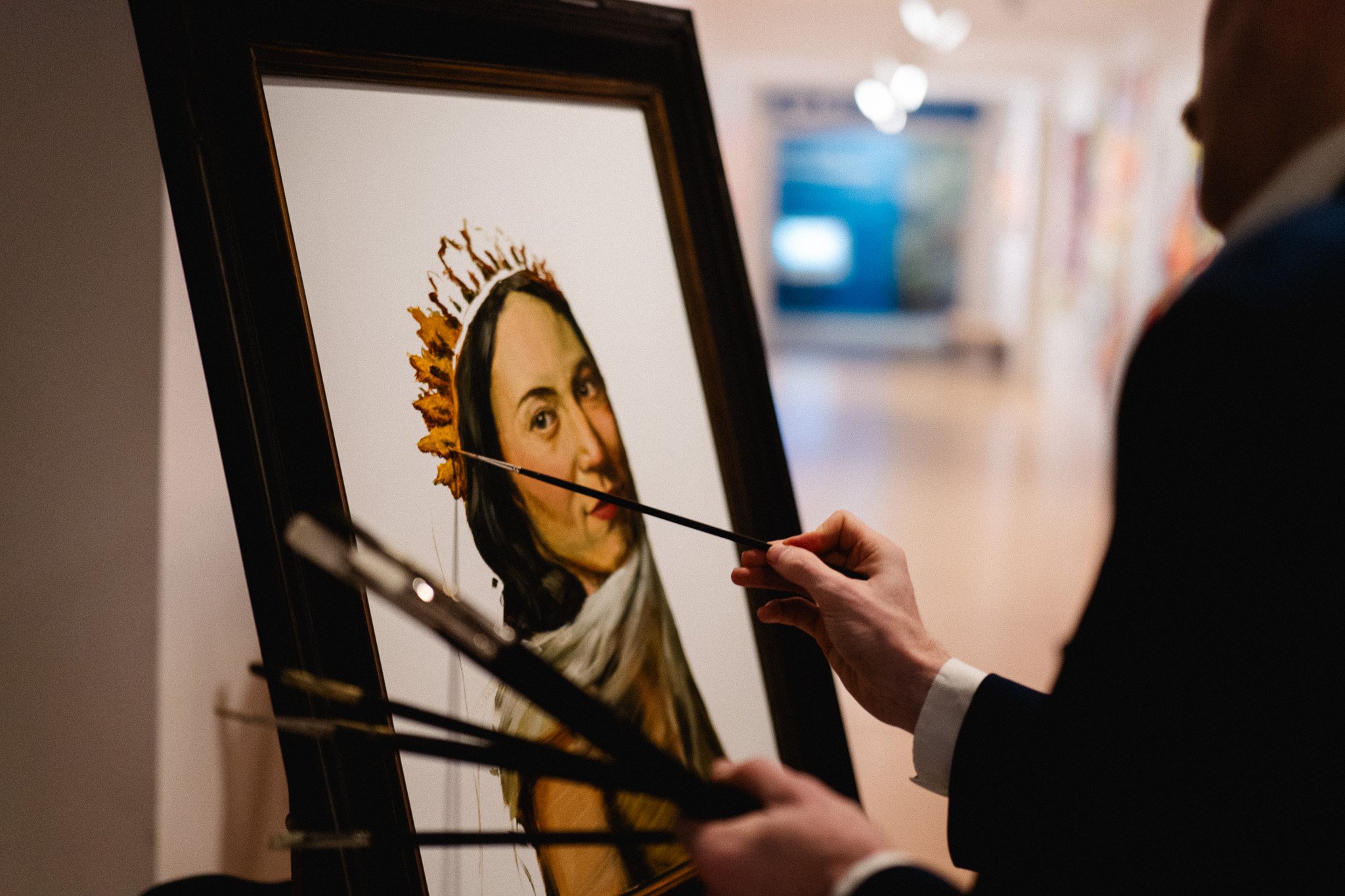 Live portrait painting in progress at formal event with artist applying final brushstrokes