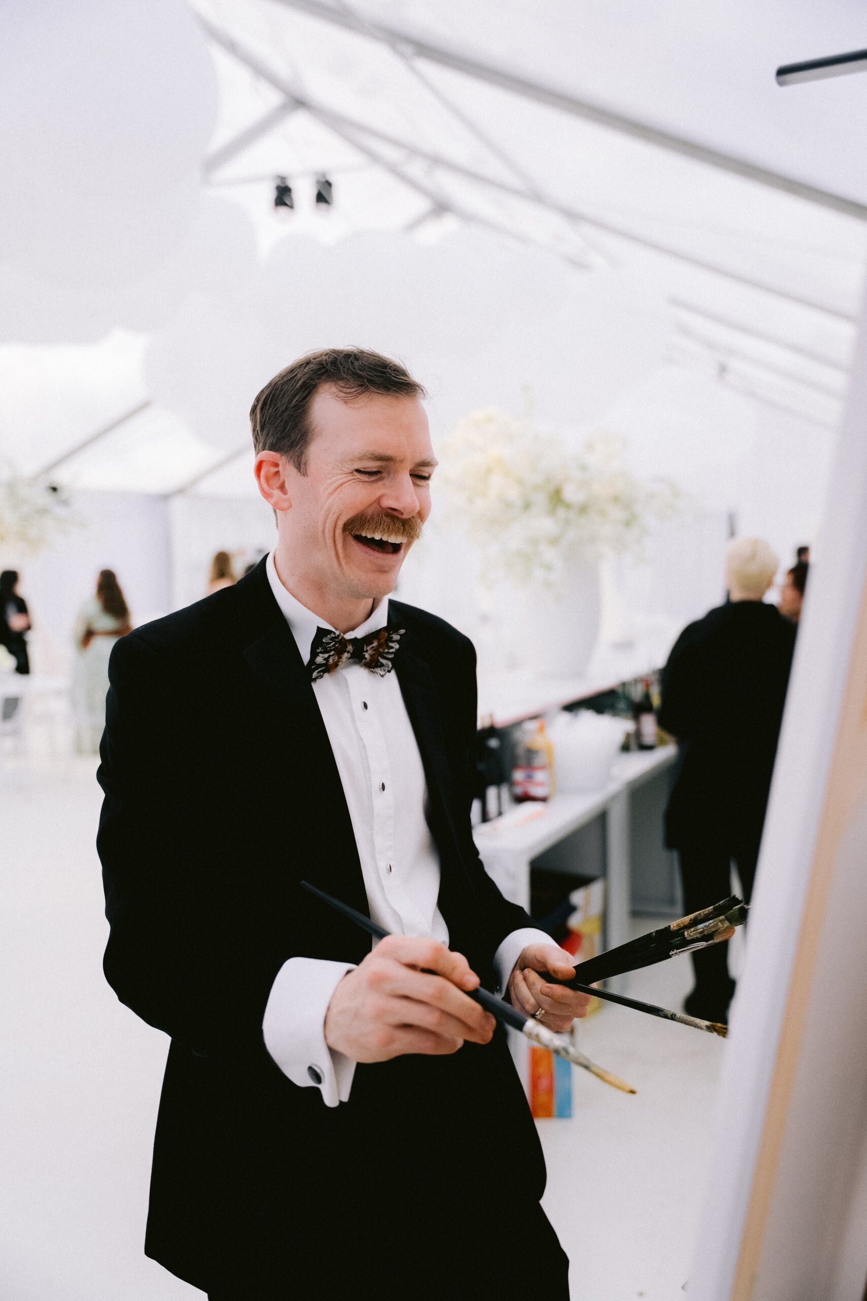 live portrait painting artist in tuxedo at Savannah gala event creating oil painting during cocktail hour
