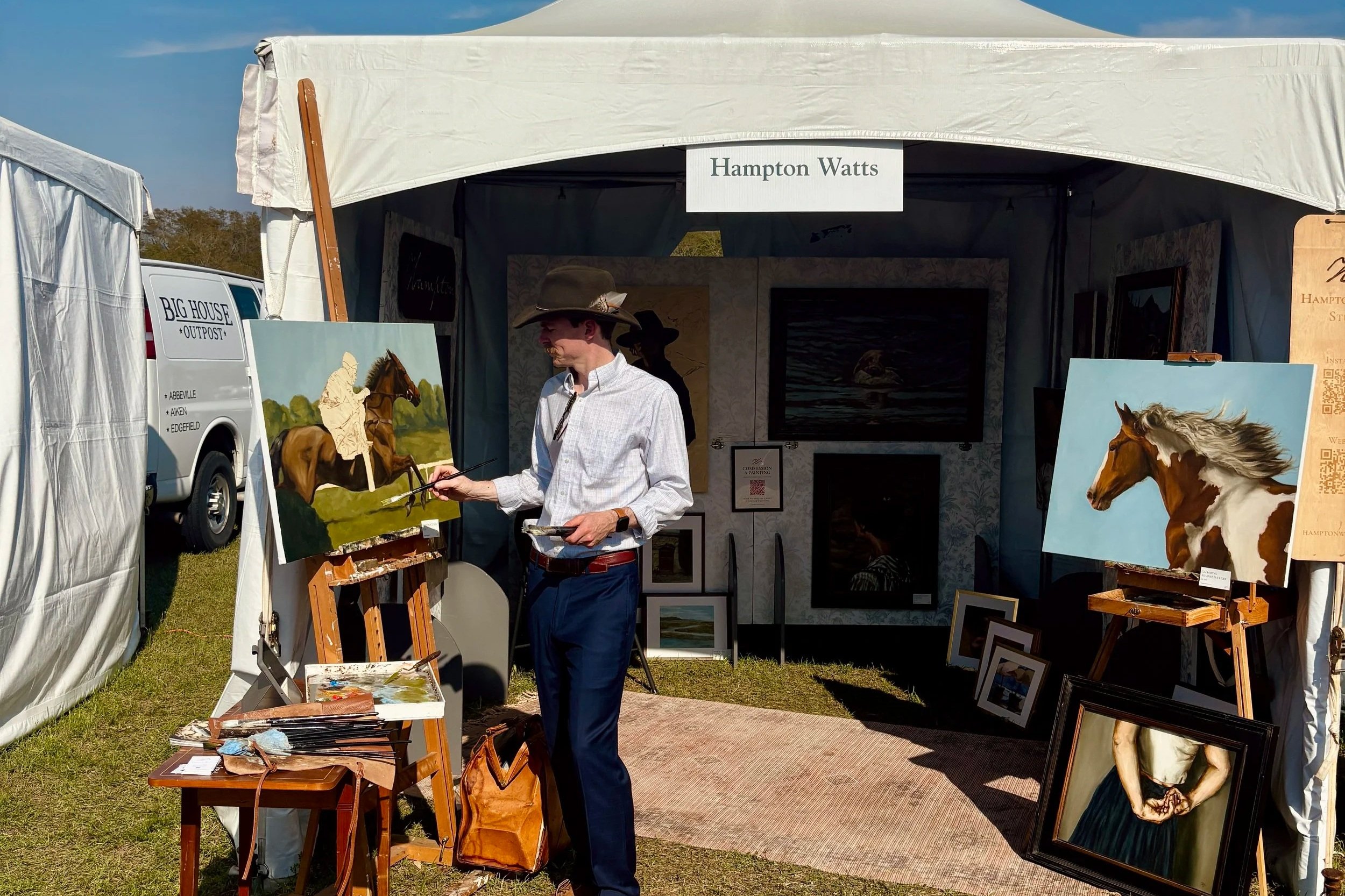 Southern heritage painter Hampton Watts painting live at the Aiken Steeplechase Racecourse, with equestrian oil paintings displayed in his booth