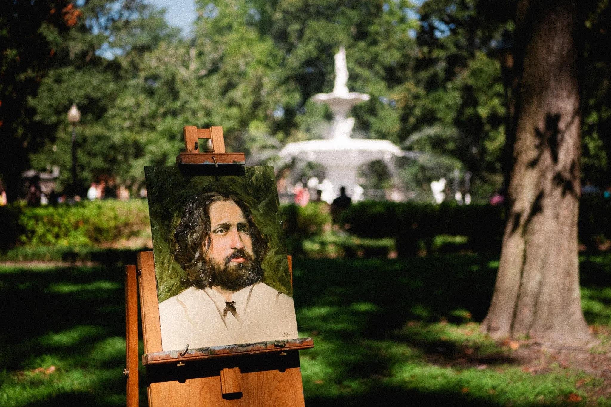 finished oil portrait painting on easel in Forsyth Park Savannah with fountain in background