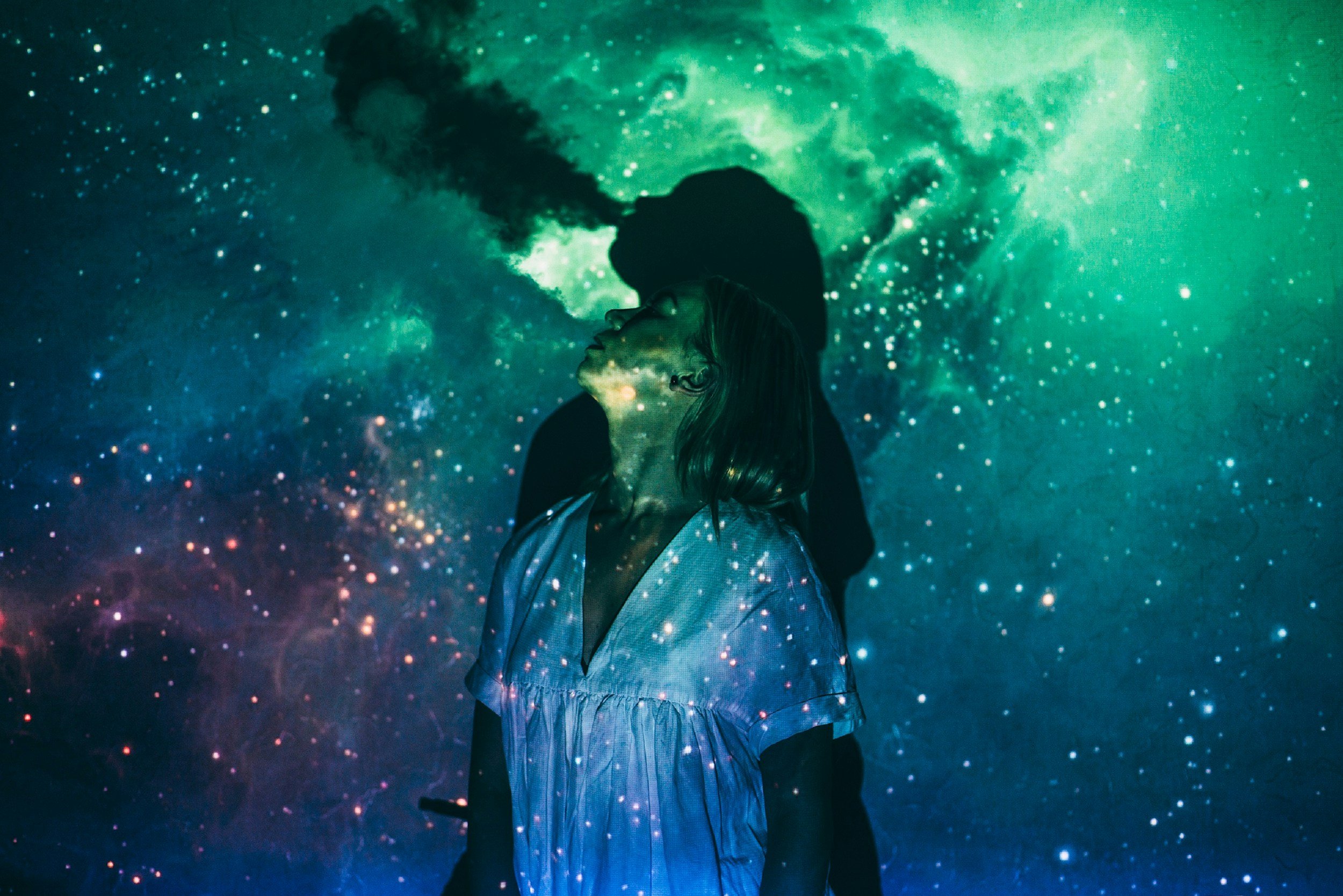 Woman with a galaxy backdrop representing learning astrology, self-discovery, and cosmic awareness.