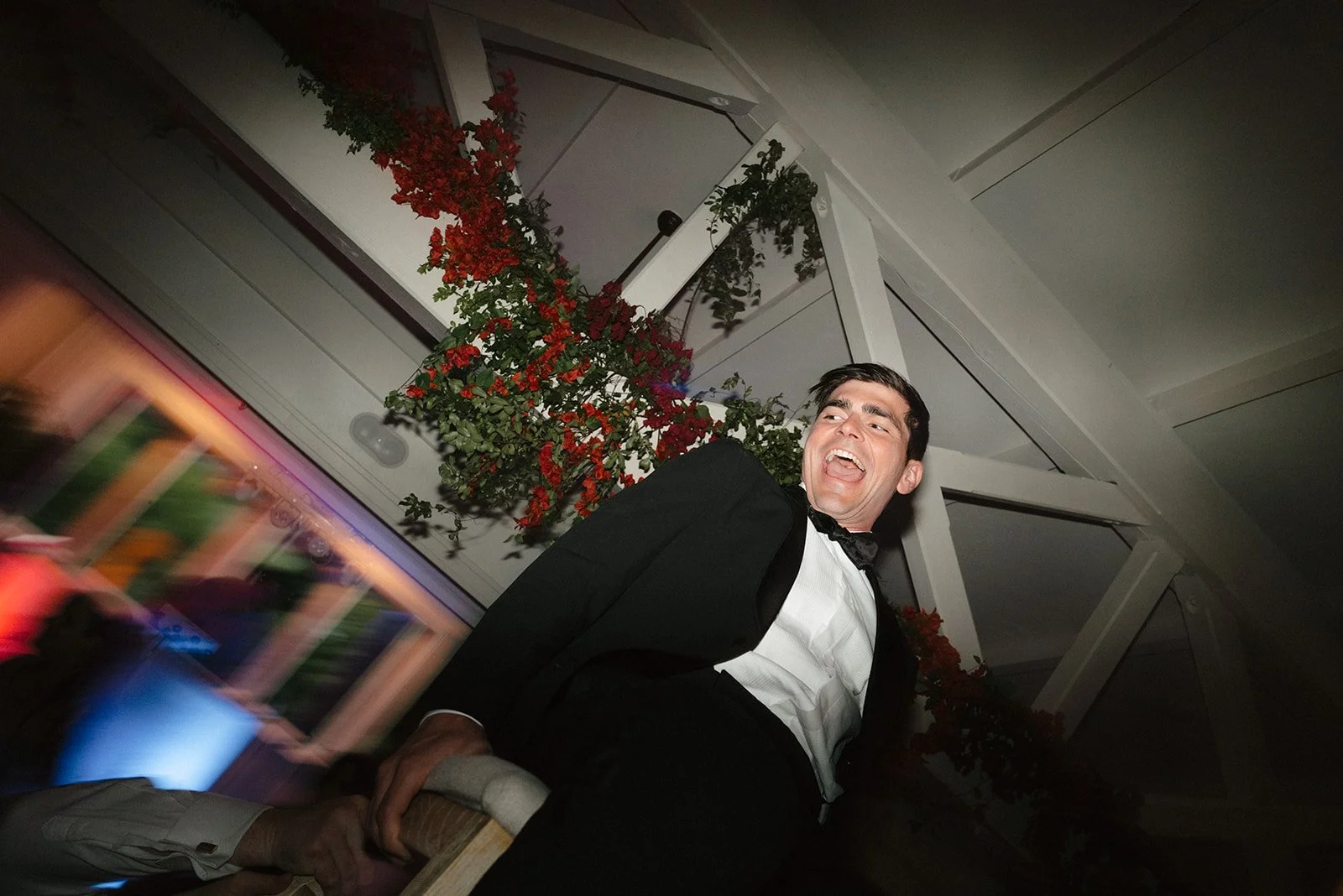 groom smiling, being carried on a chair