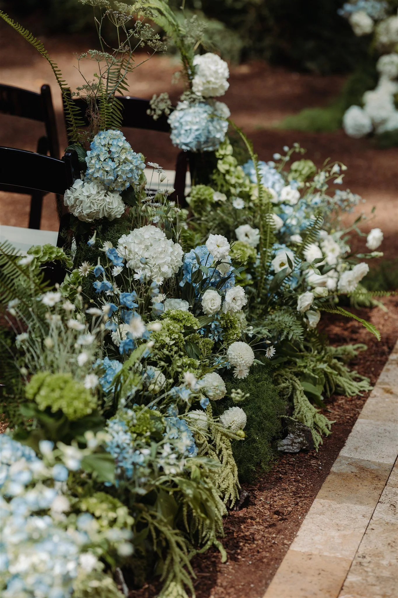 lush wedding aisle with blue and white flowers