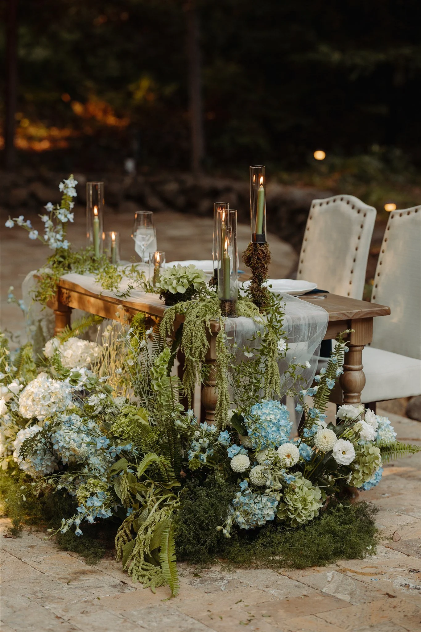 wedding sweetheart table with green candles and moss