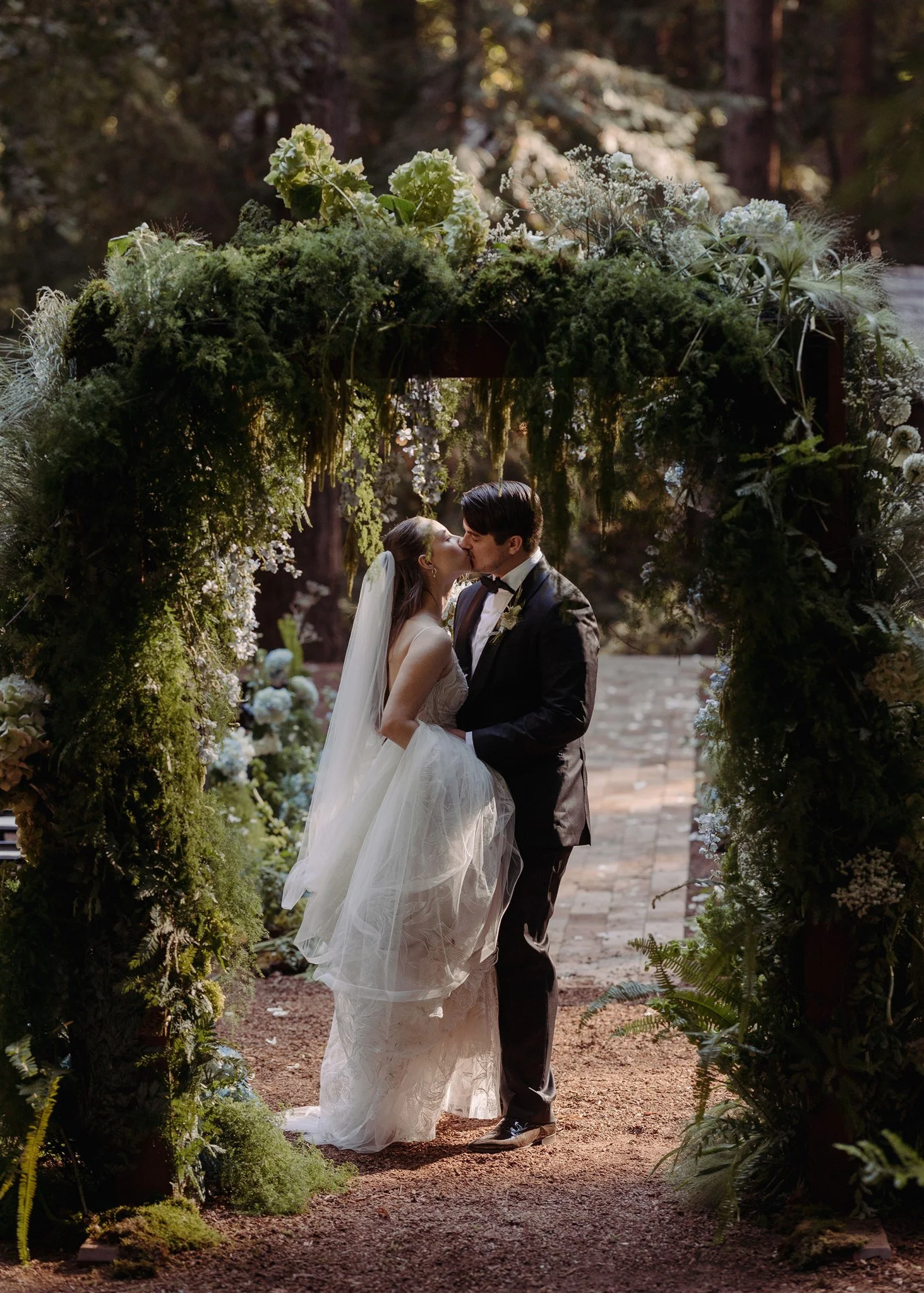 back of wedding arch with couple kissing