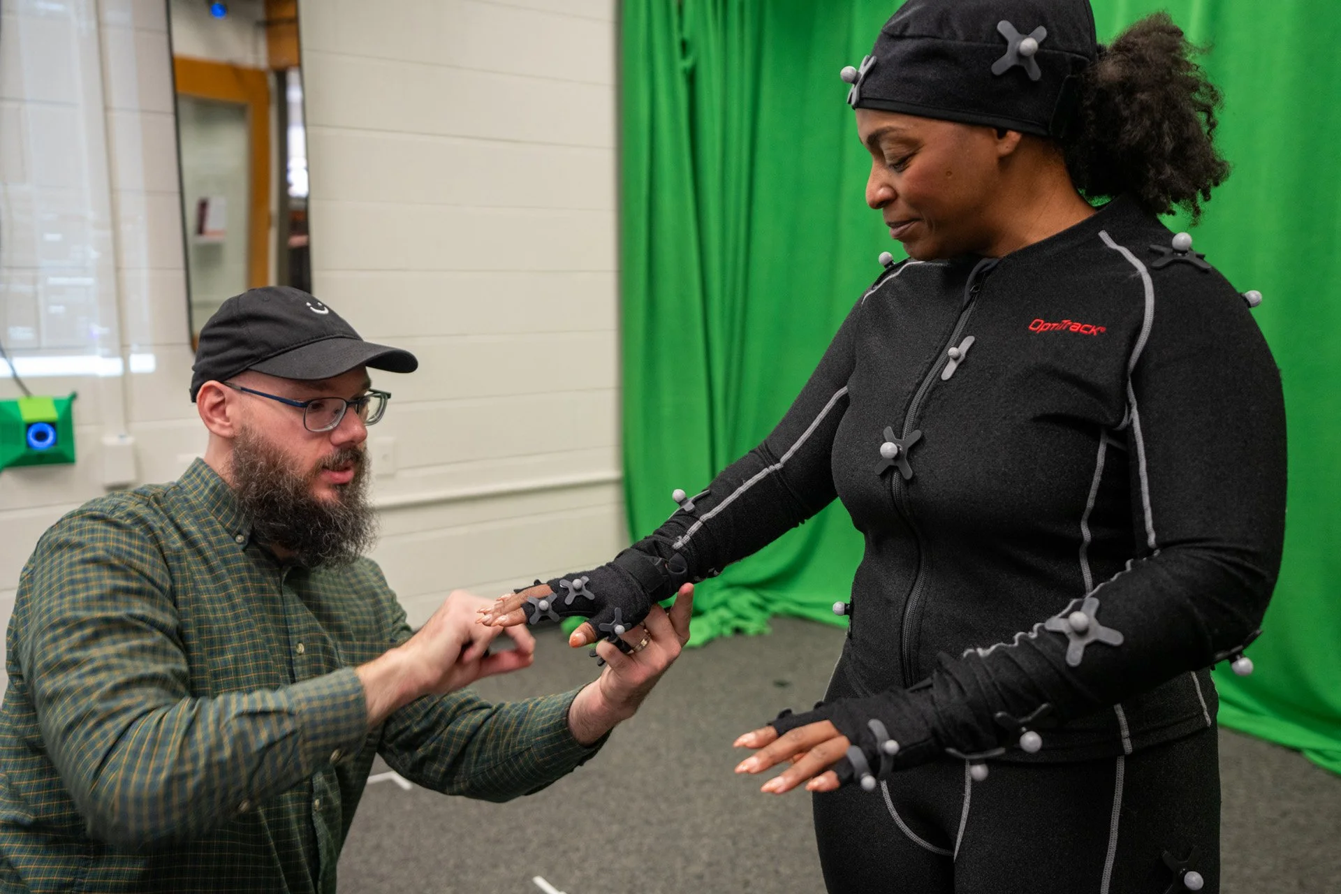 Trevor Finney assisting Brittney Harris with the Optitrack motion capture suit. Photo by Clark Dehart for Virginia Tech.