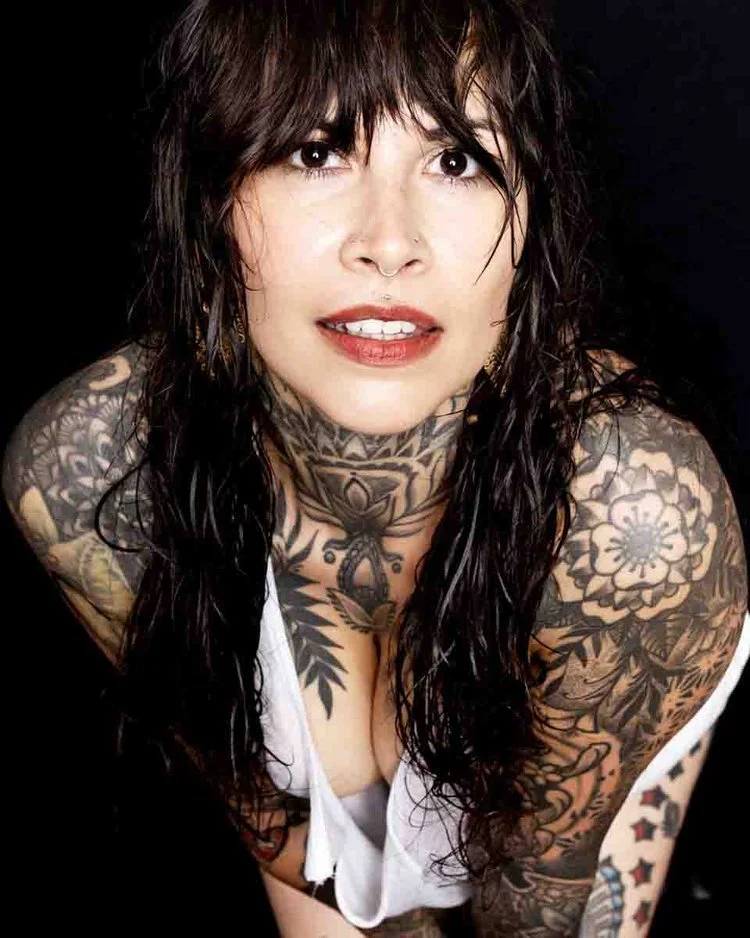 Portrait of tattooed woman with wet brown hair