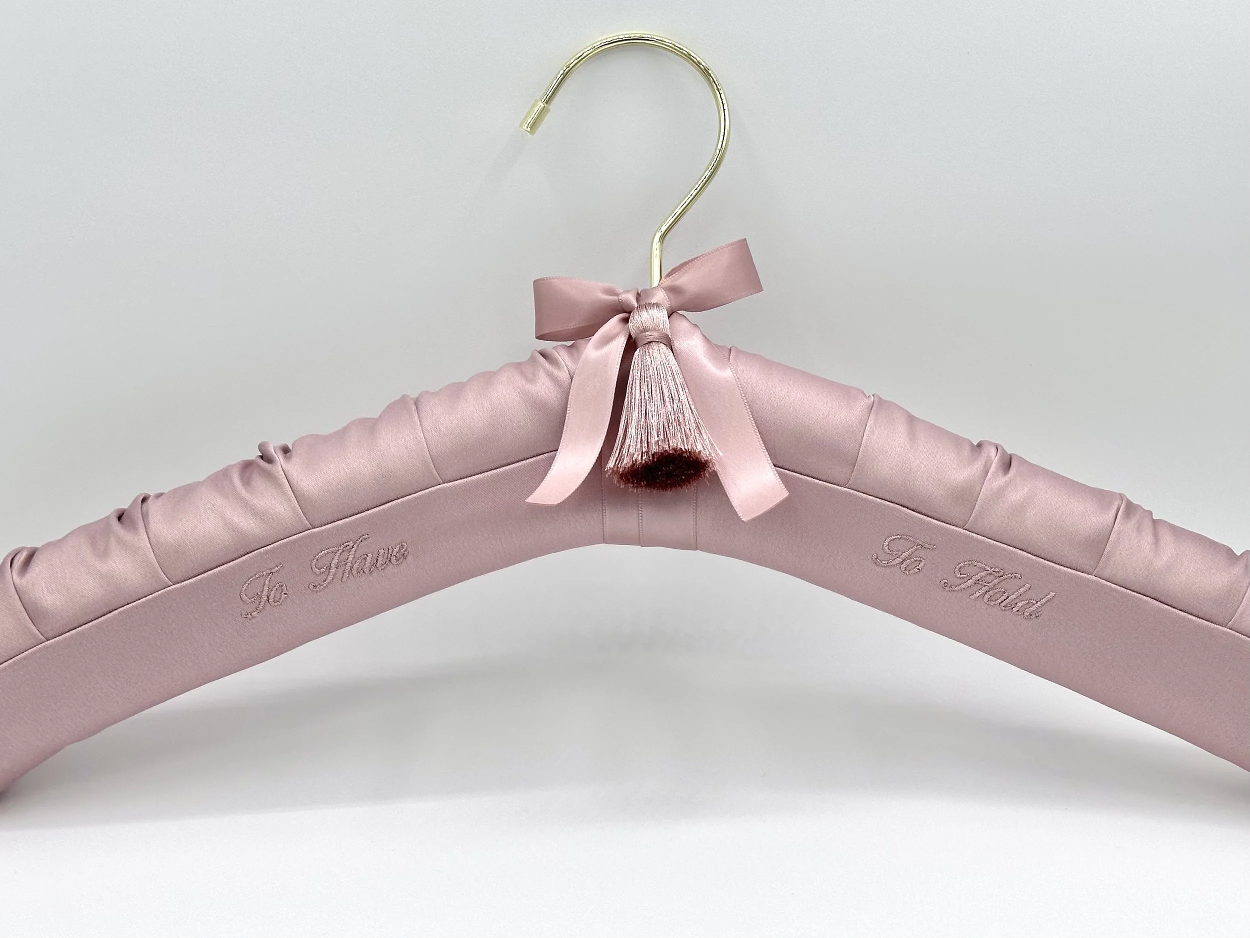 To Have To Hold on rose satin bridal hanger with gold hanger finish, with ribbon and tassel.  Custom wedding hanger by the boondock quilt co