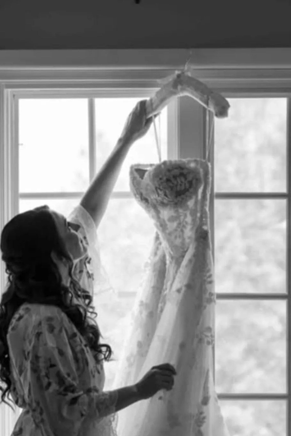 A bride is admiring her personalized satin bridal hanger customized with her to be married name. A perfect keepsake for brides..