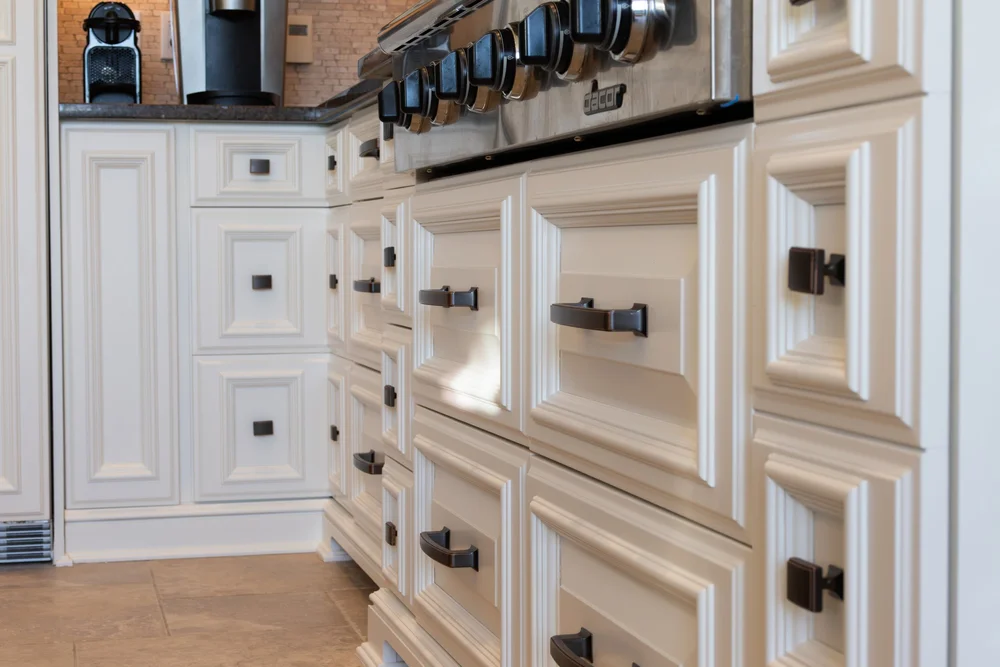 Close-up of white cabinet doors and drawers with dark handles from McHugh Painting’s cabinet gallery.