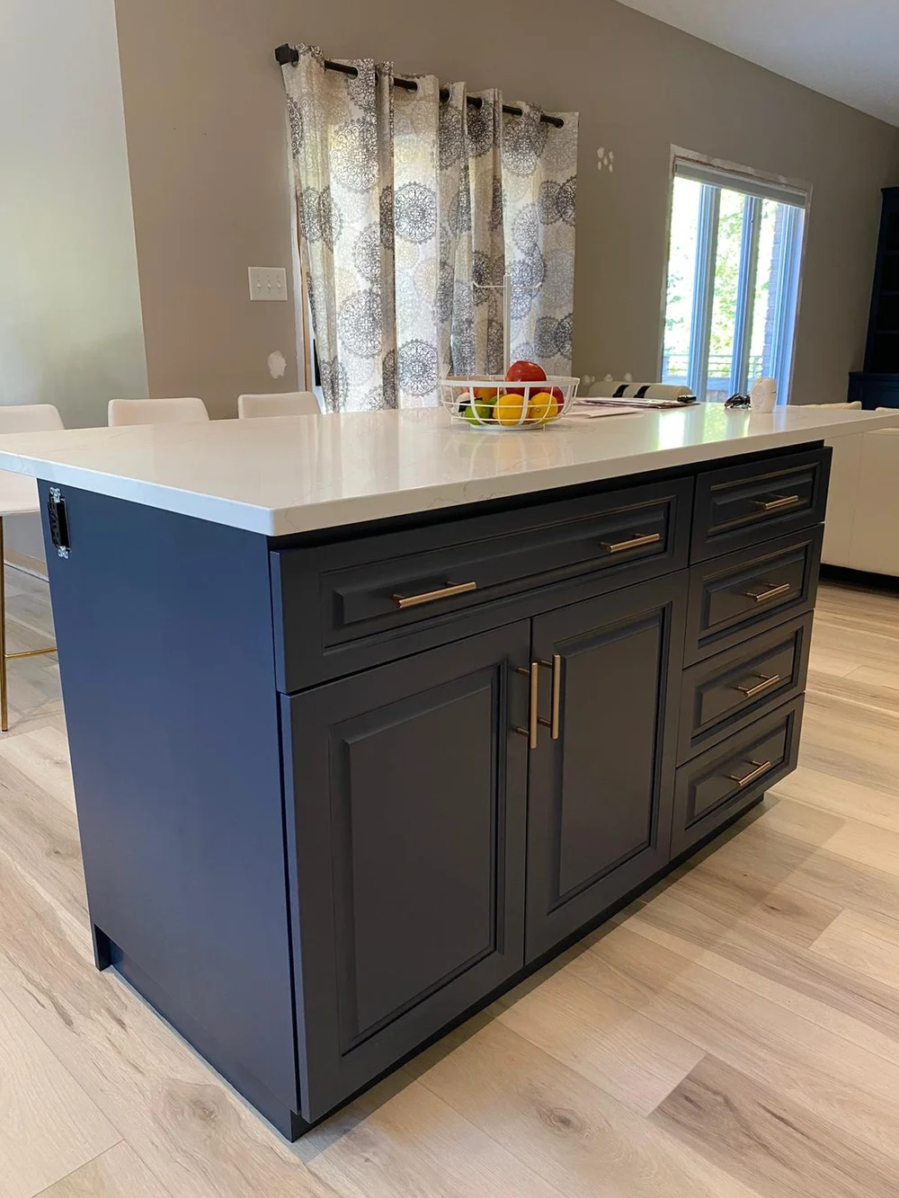 Navy blue kitchen island with a white countertop and brass-coloured handles, from McHugh Painting’s cabinet refinishing gallery.