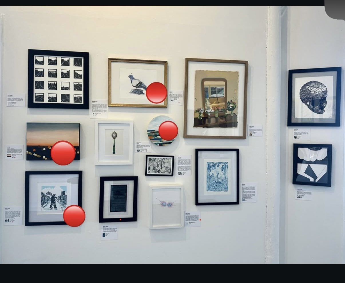 A gallery wall displays various framed artworks and photographs, with some tags and descriptions. Four of the artworks are obscured by red circular overlays.